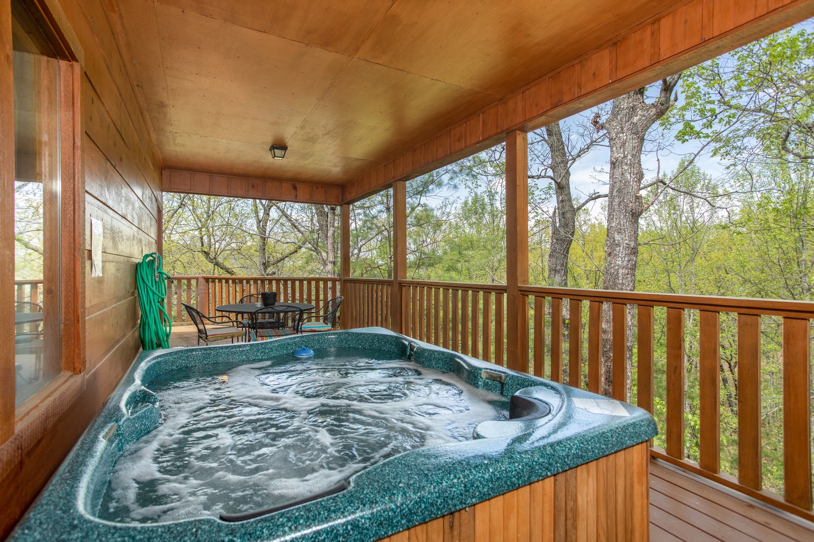 Hot tub on a covered deck at Hillside Haven, a 1 bedroom cabin rental located in Pigeon Forge