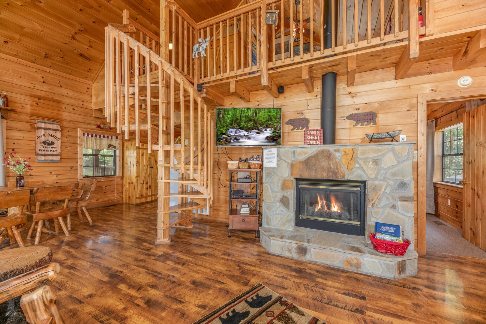 Living room with fireplace, TV, and spiral staircase at Away From it All, a 1 bedroom cabin rental located in Pigeon Forge