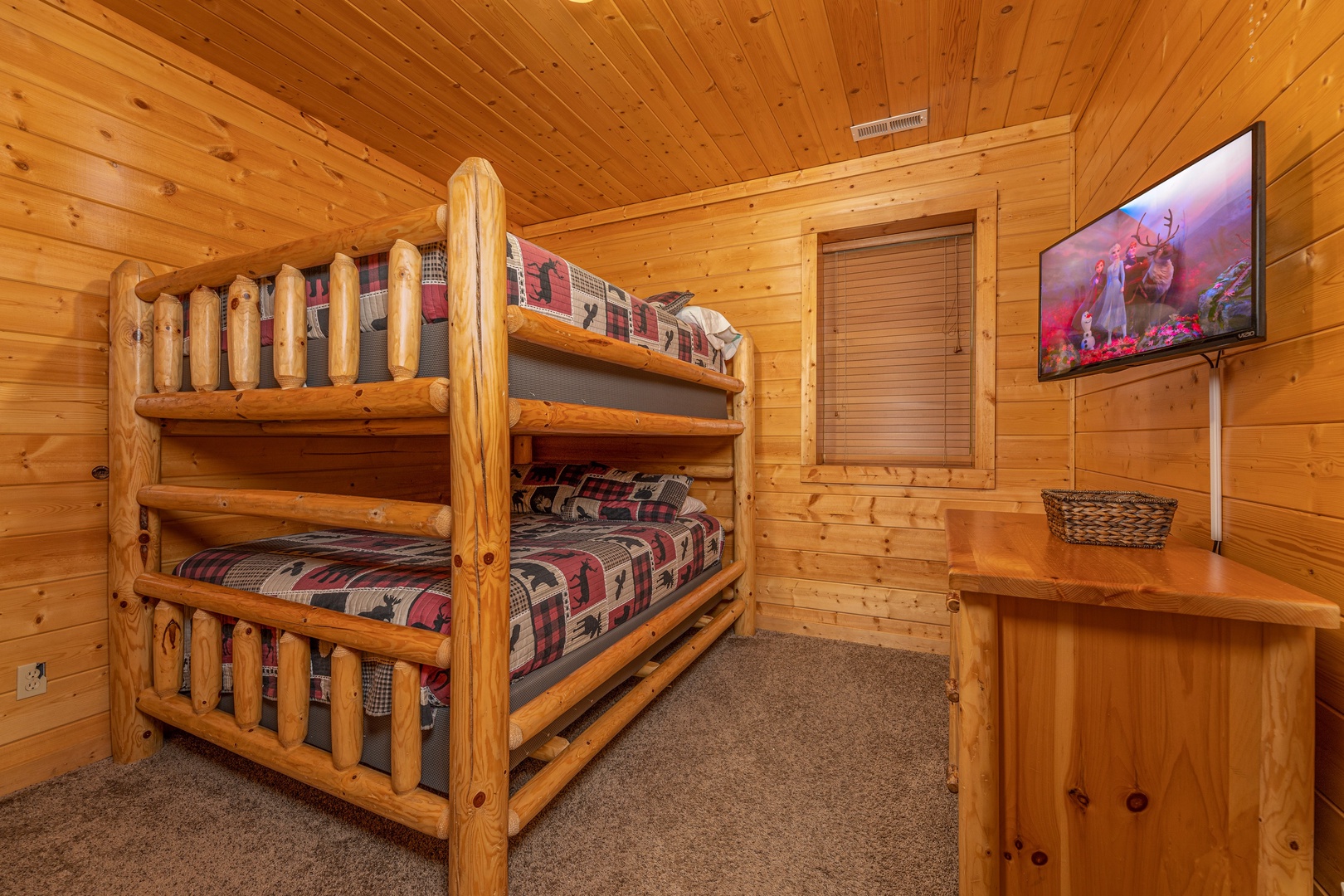 Bunk beds, dresser, and TV in a bedroom at Grizzly's Den, a 5 bedroom cabin rental located in Gatlinburg