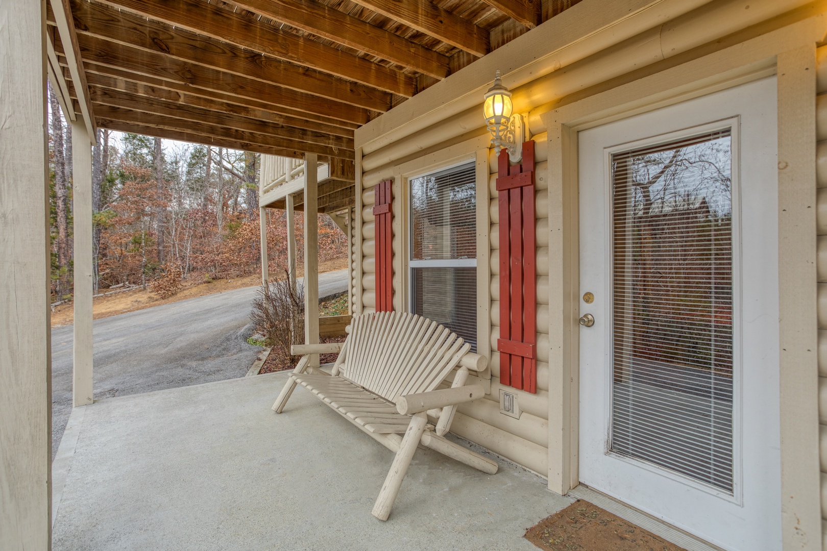 Porch with a log Adirondack bench at Bearly in the Mountains, a 5-bedroom cabin rental located in Pigeon Forge