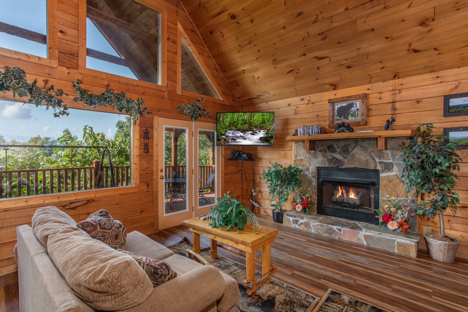 stone fireplace and wall mounted television at angel's majestic view a 3 bedroom cabin rental located in pigeon forge