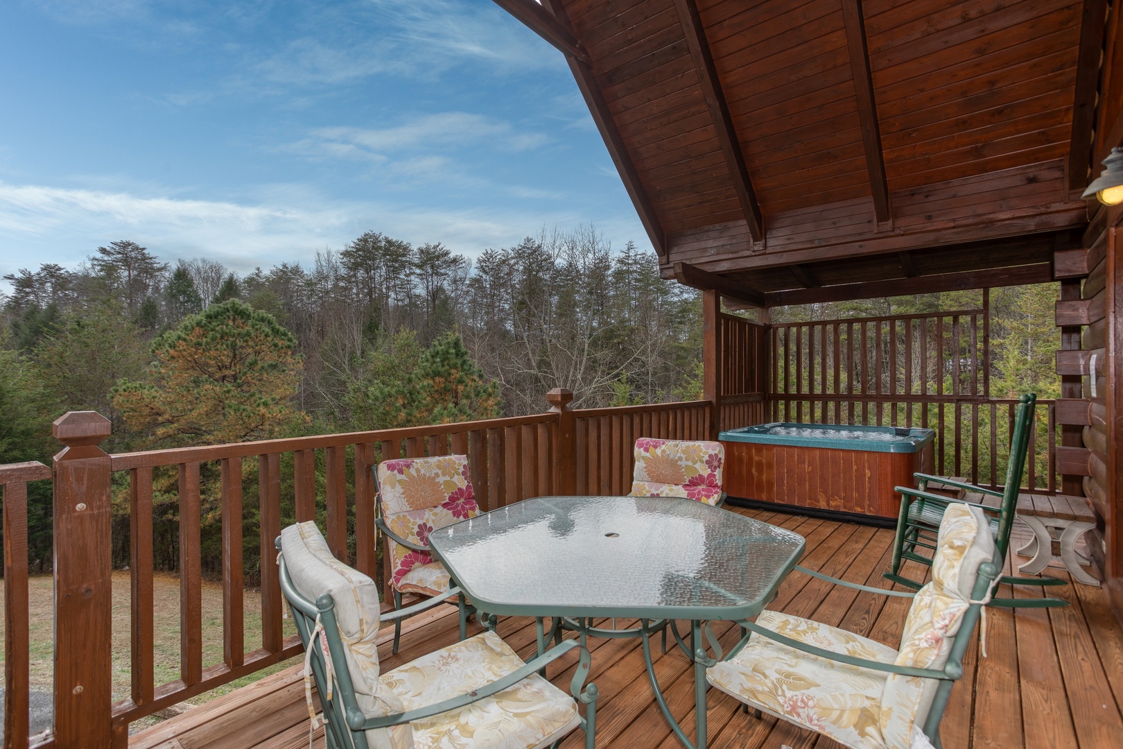 Covered deck with dining table for four at Hibernation Station, a 3-bedroom cabin rental located in Pigeon Forge