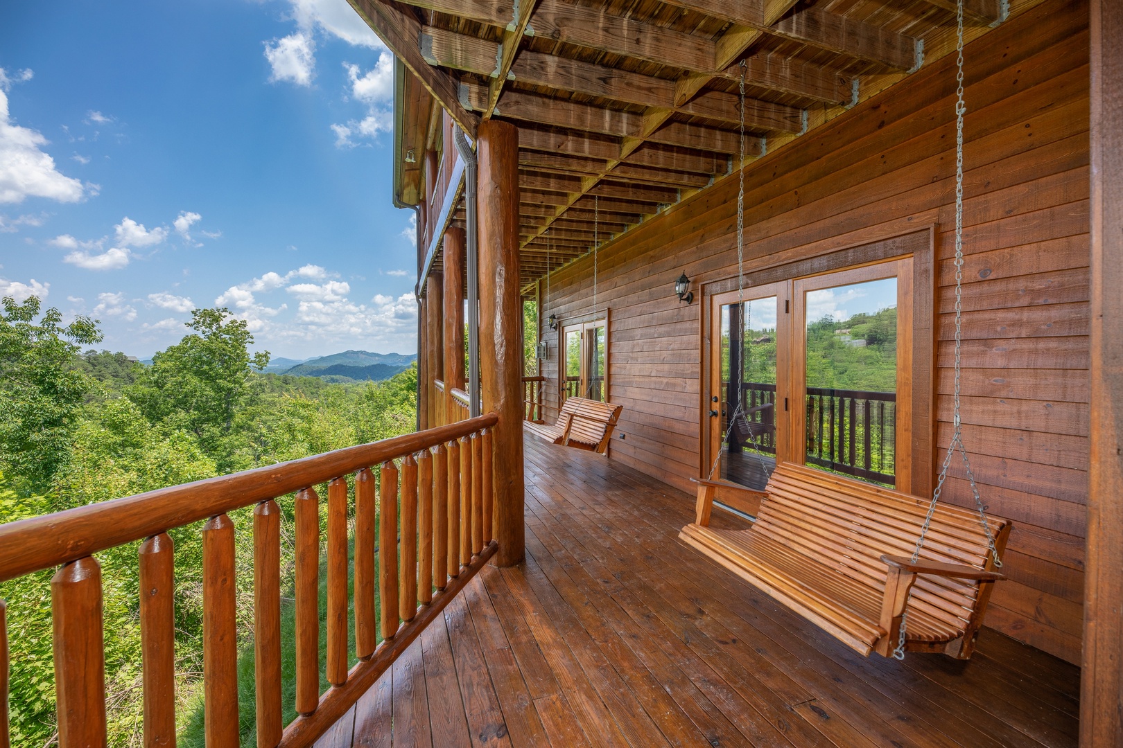 Swings on a covered deck at God's Country, a 4 bedroom cabin rental located in Pigeon Forge