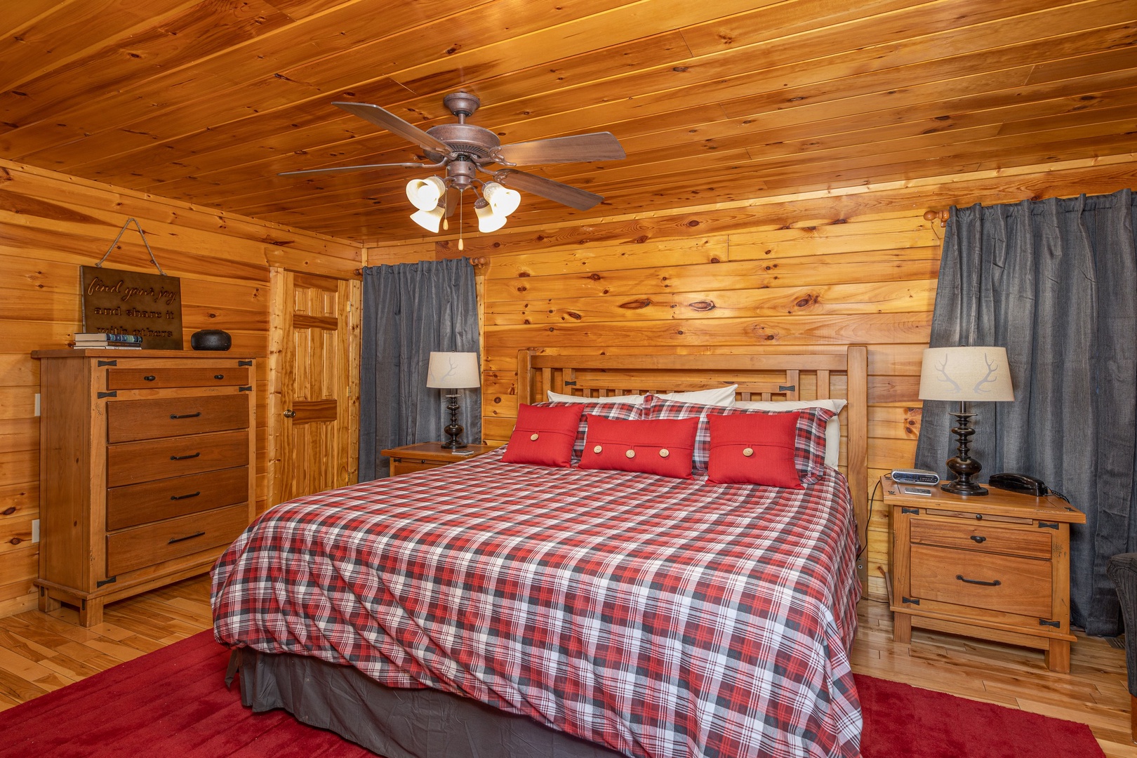 Bedroom with a king bed, night stands and lamps, and a dresser at Whispering Grace, a 2 bedroom cabin rental located in Gatlinburg