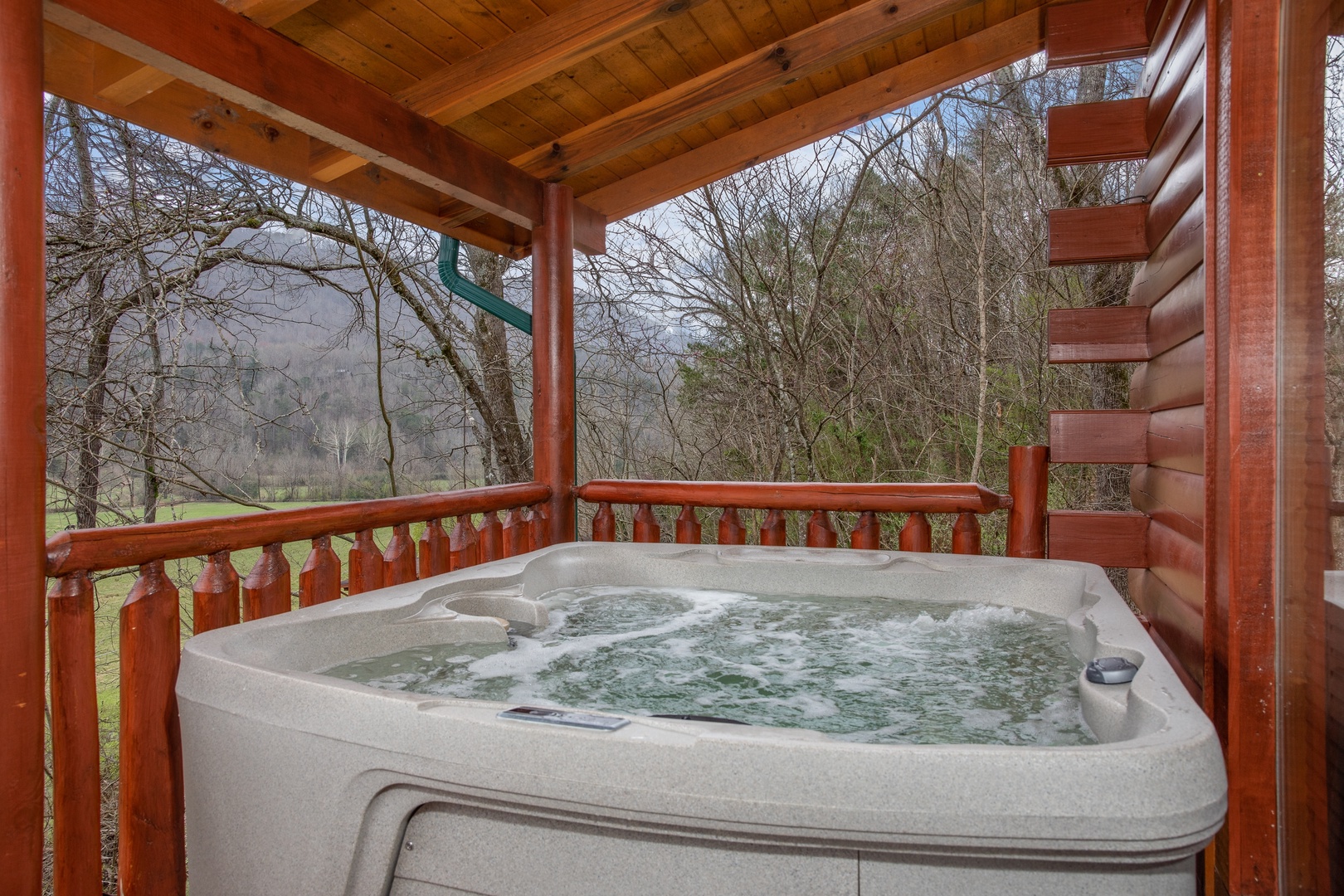 Hot tub on a covered deck at Mountain View Meadows, a 3 bedroom cabin rental located in Pigeon Forge