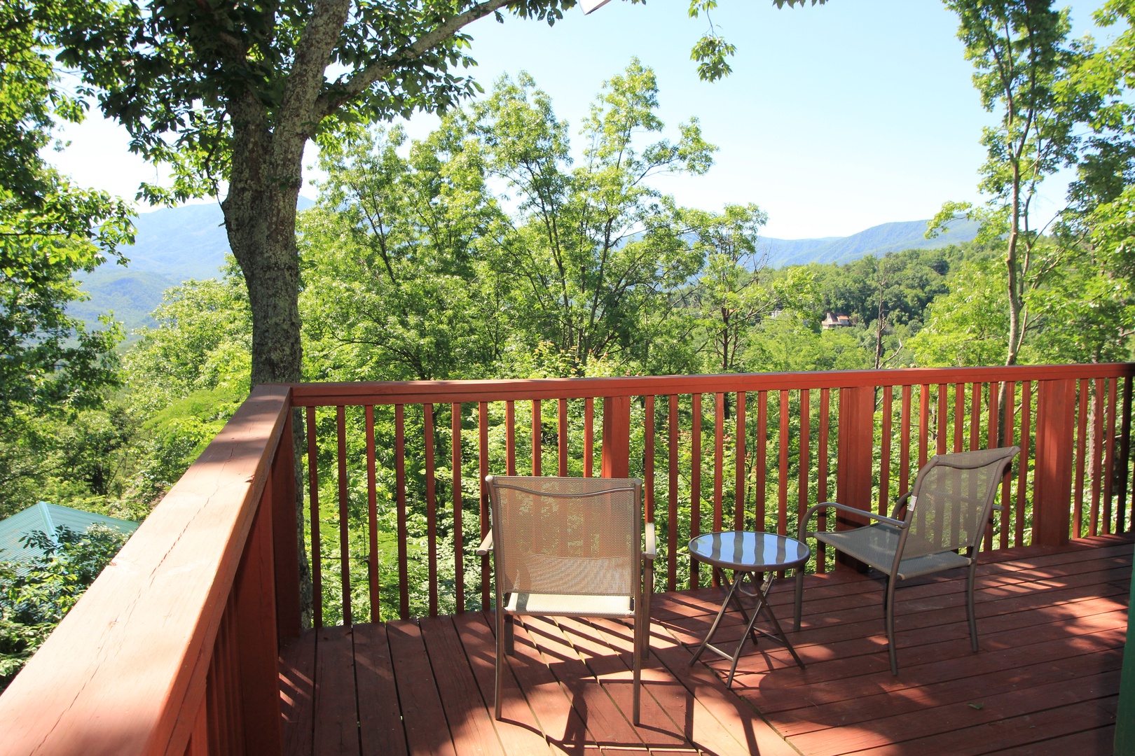Two chairs and a drink table overlooking the mountains at Bushwood Lodge, a 3-bedroom cabin rental located in Gatlinburg