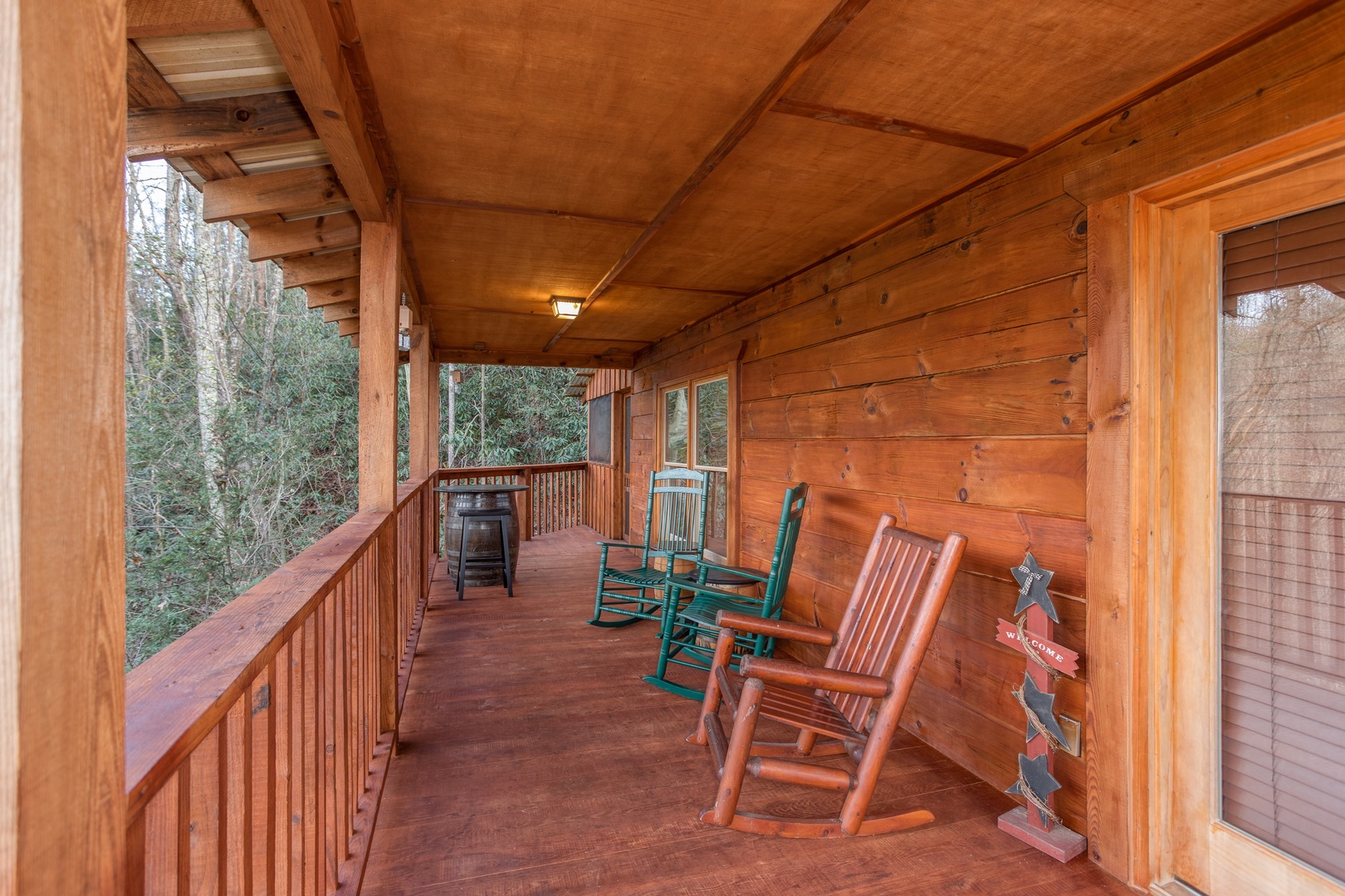 Covered deck with rocking chairs at Moonshiner's Ridge, a 1-bedroom cabin rental located in Pigeon Forge