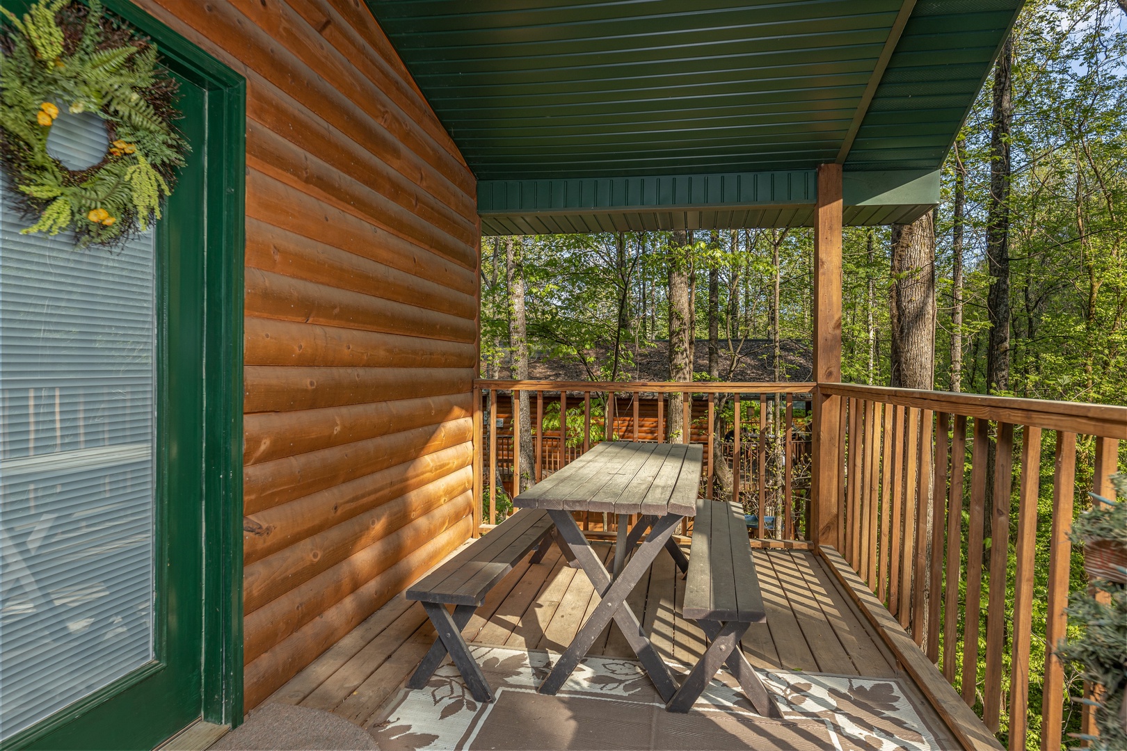 Picnic table on a covered deck at A Cheerful Heart, a 2 bedroom cabin rental located in Pigeon Forge