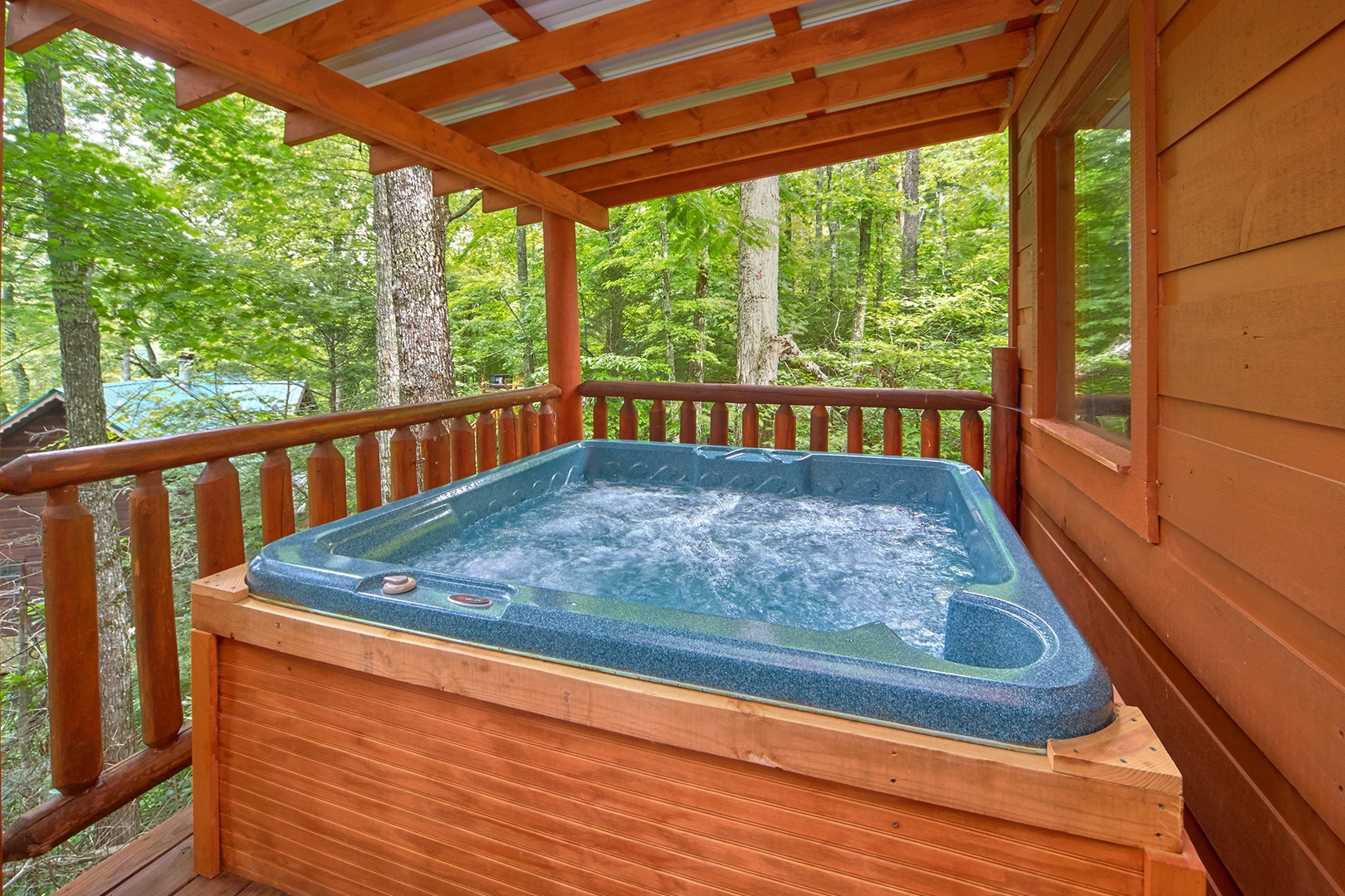 Hot tub on a covered deck at Love Struck, a 1 bedroom cabin rental located in Pigeon Forge