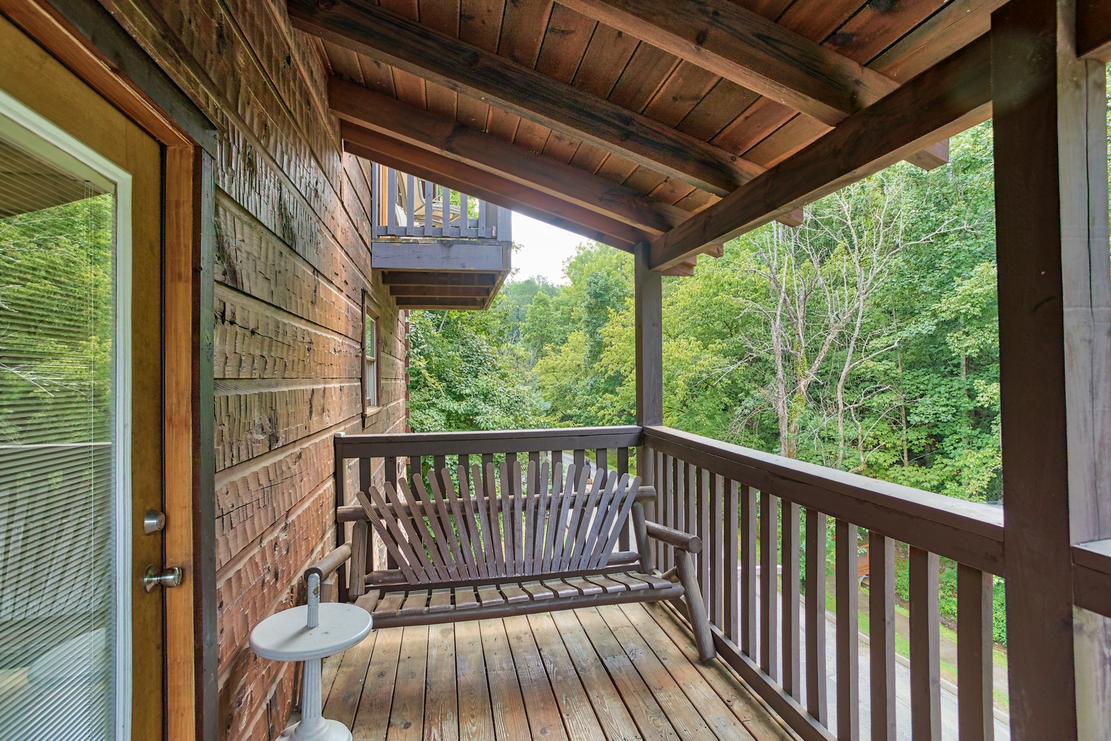 Bench on a covered deck at Mountain Music, a 5 bedroom cabin rental located in Pigeon Forge
