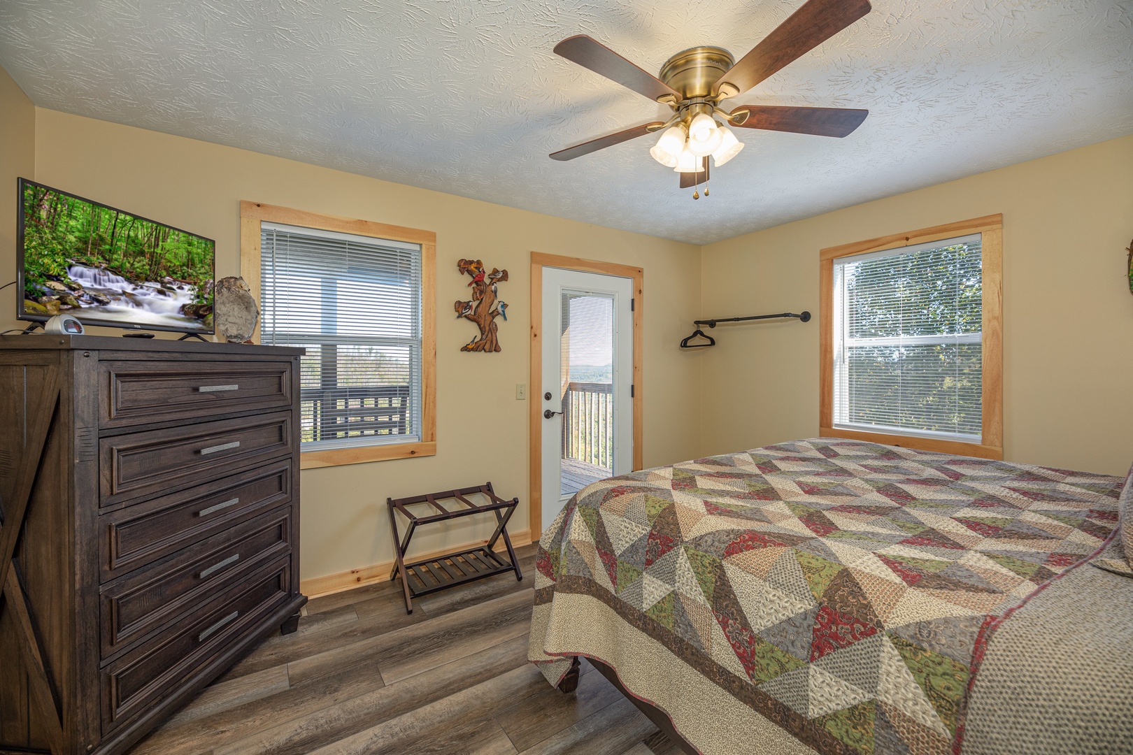 Dresser, TV, and deck access in a bedroom at Le Bear Chalet, a 7 bedroom cabin rental located in Gatlinburg
