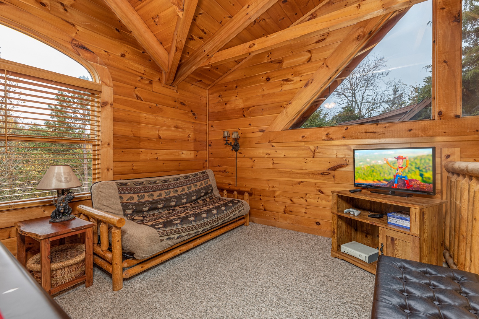Futon and TV in the loft at Livin' Simple, a 2 bedroom cabin rental located in Pigeon Forge