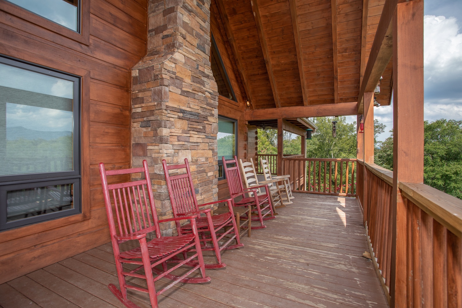 Rocking chairs on a covered deck at Cedar Creeks, a 2-bedroom cabin rental located near Douglas Lake