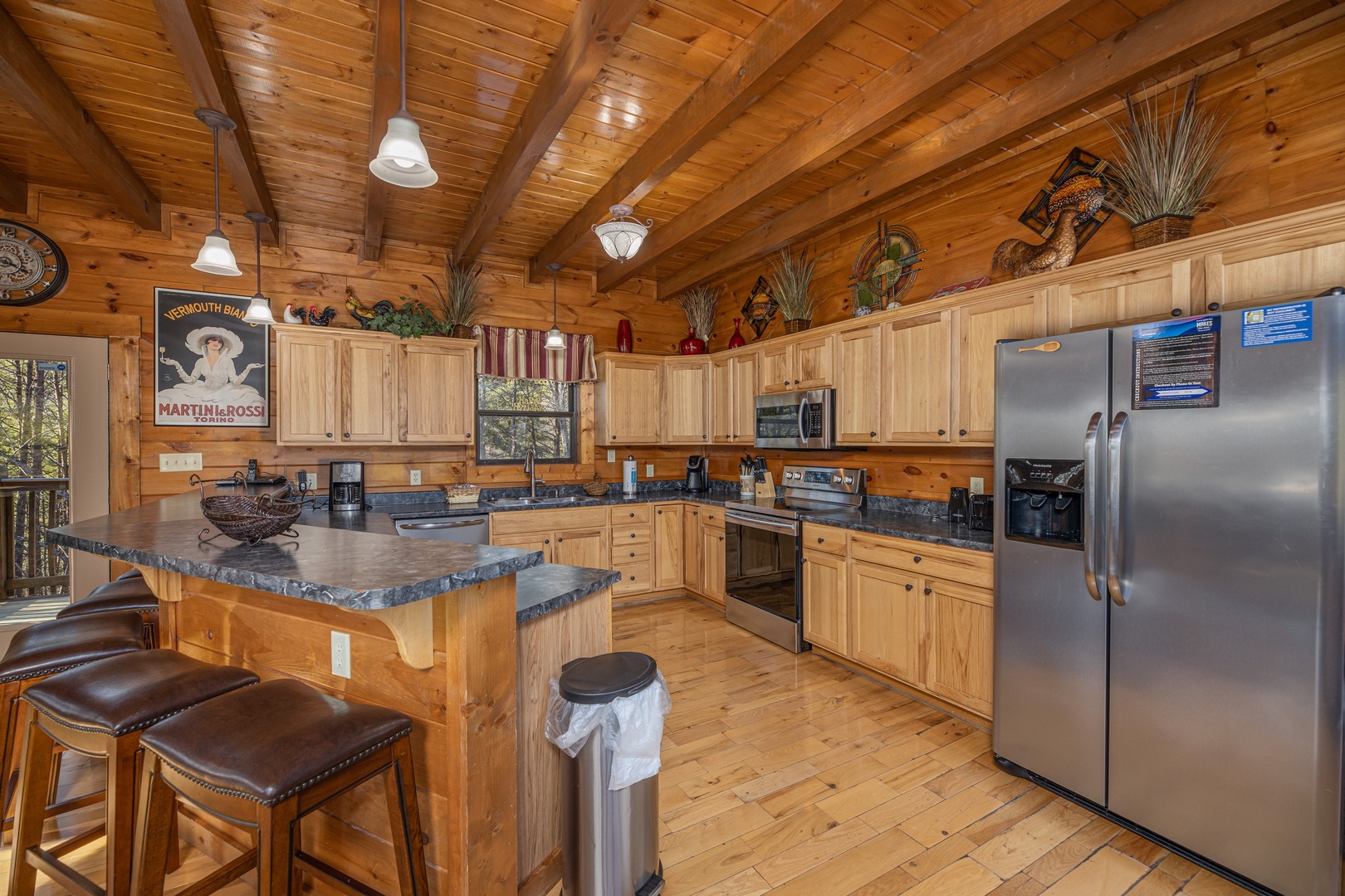 Island breakfast bar in a kitchen with stainless appliances at King of the Mountain, a 3 bedroom cabin rental located in Pigeon Forge
