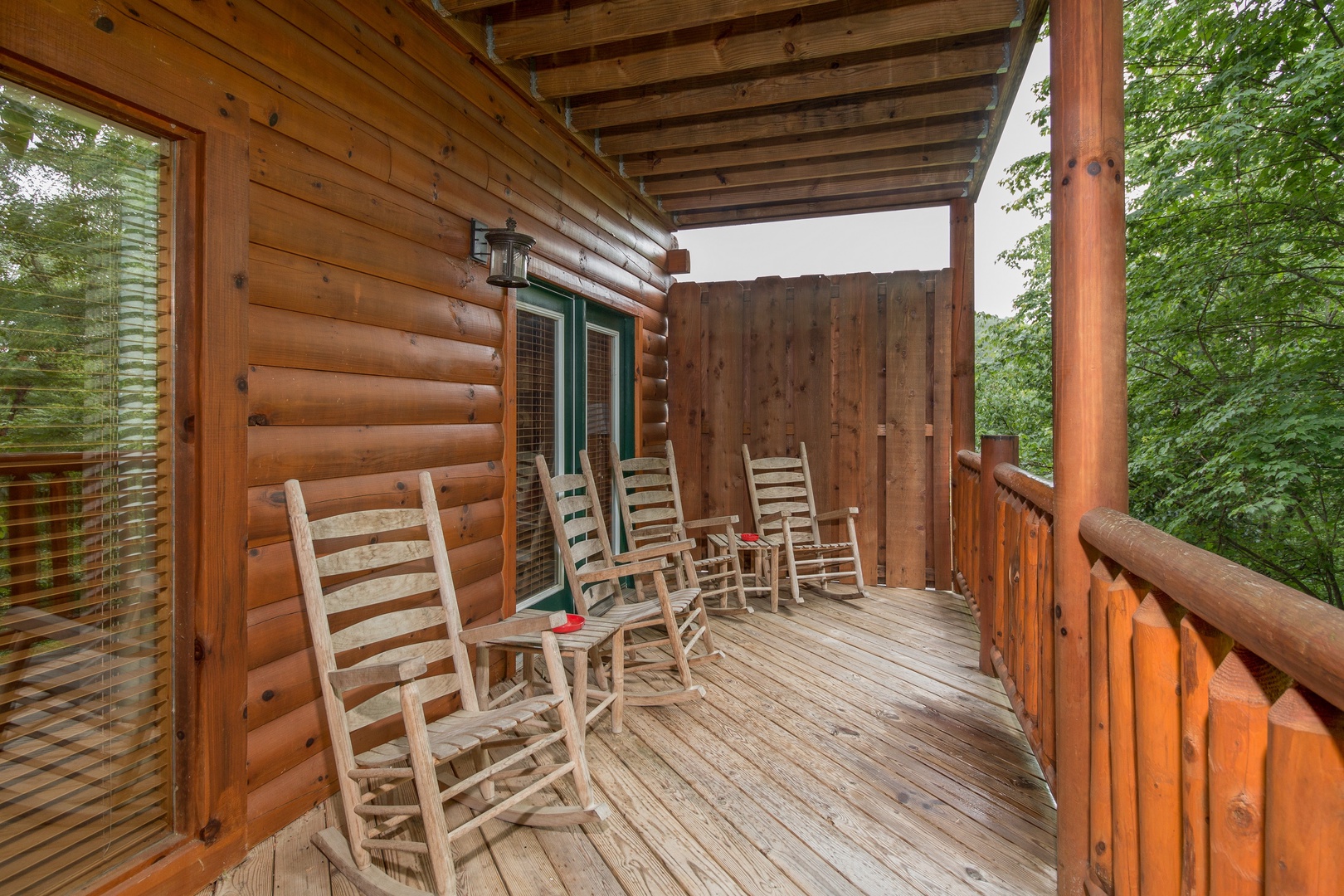 Rockers with side tables on Covered Deck at Family Ties Lodge, a 4 bedroom cabin rental located in pigeon forge