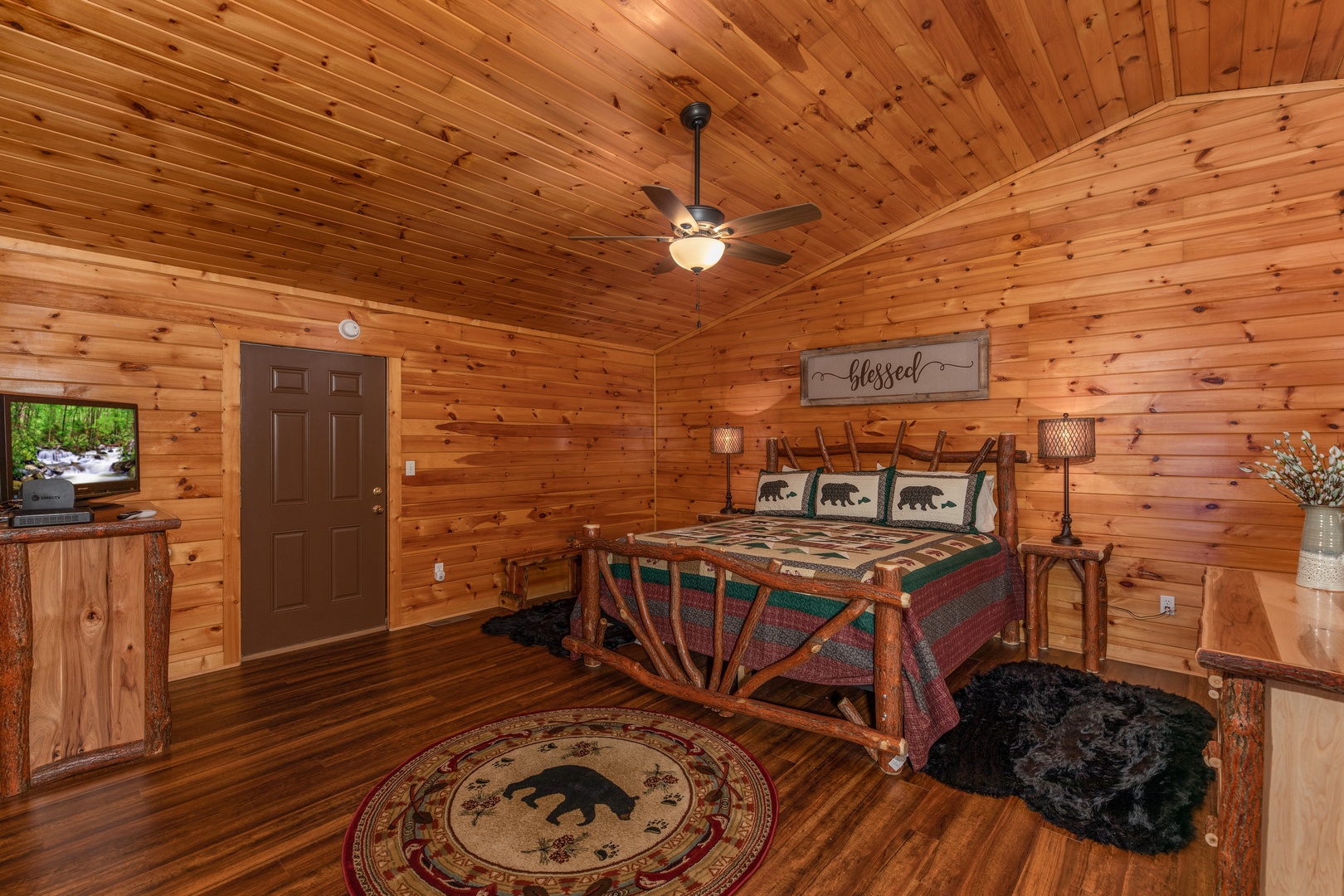 Bedroom with a log bed, dressers, and a TV at Hawk's Heart Lodge, a 3 bedroom cabin rental located in Pigeon Forge