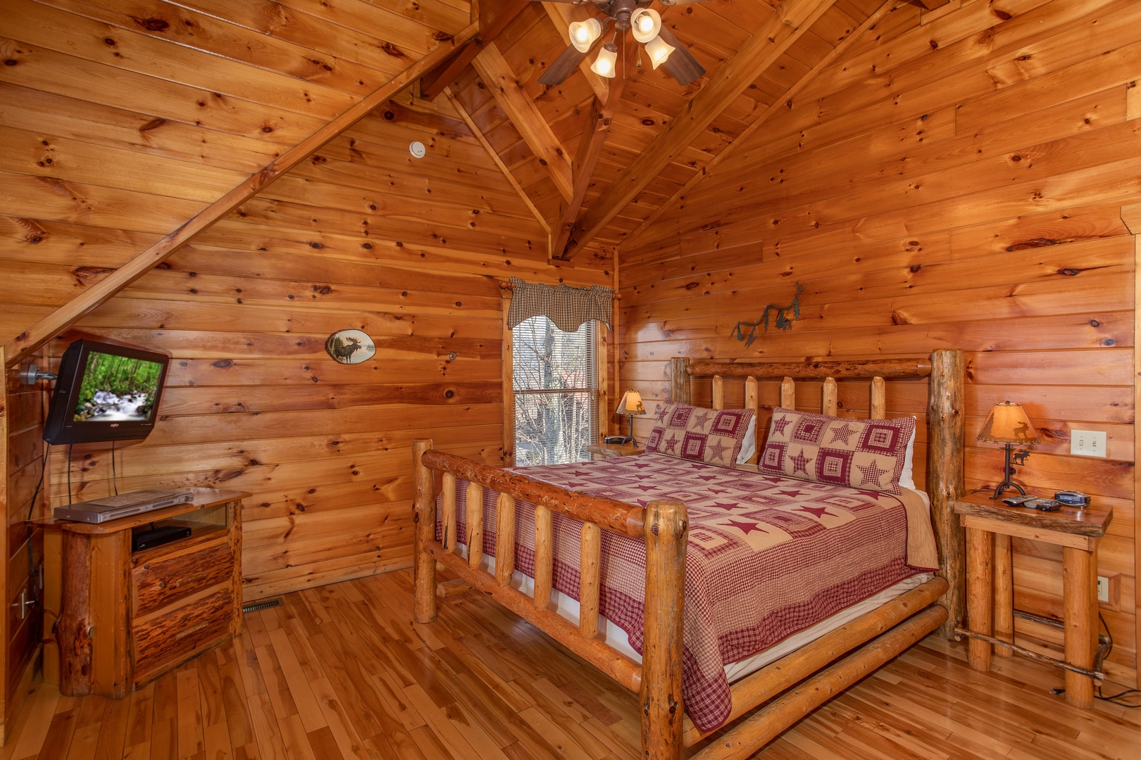 Loft bedroom with king log bed, TV, and small dresser at 5 Star View, a 3 bedroom cabin rental located in Gatlinburg