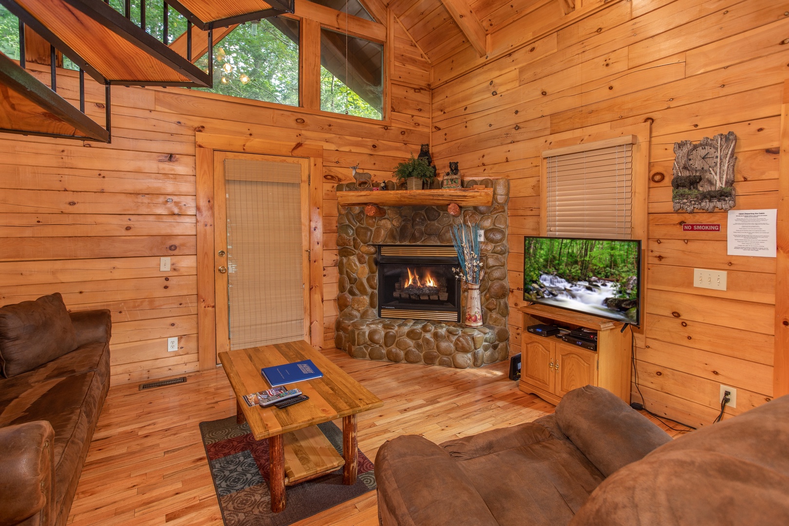 Living room with a fireplace, television, and vaulted ceiling at Dreams Do Come True, a 1-bedroom cabin rental located in Pigeon Forge