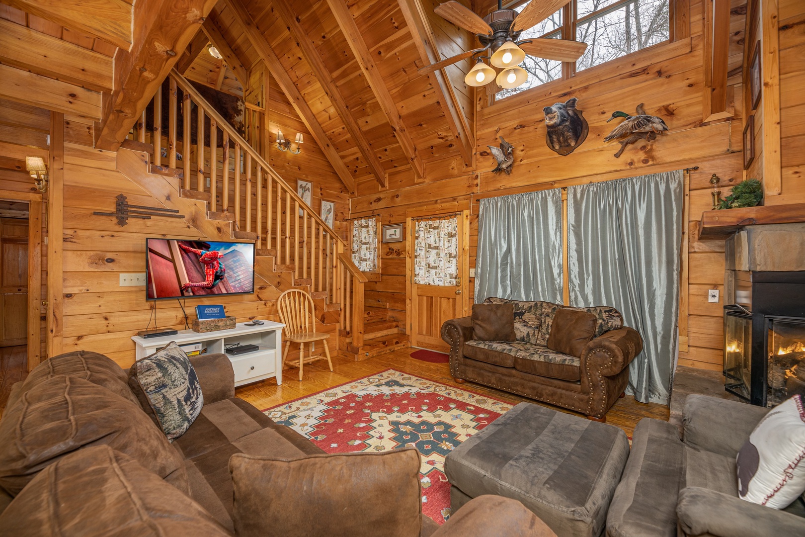Two sofas, chaise, fireplace, and TV in the living room at Fox Ridge, a 3 bedroom cabin rental located in Pigeon Forge