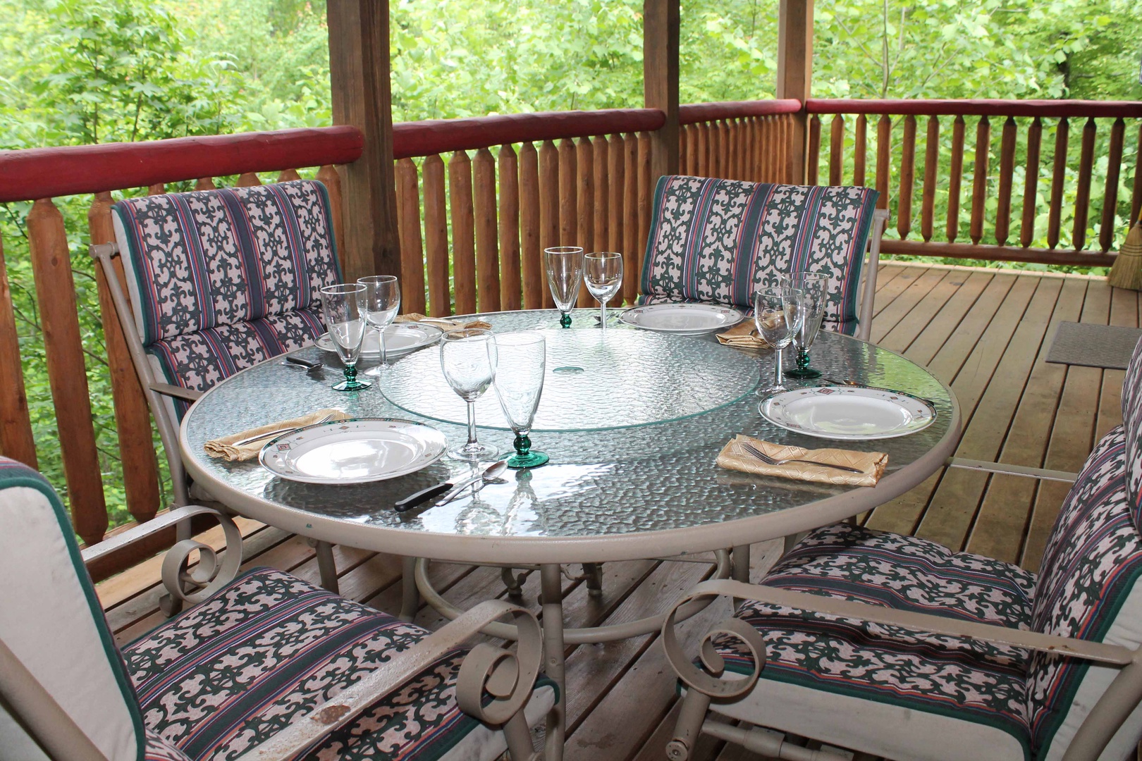 Outdoor dining set for four on the covered deck at Laid Back, a 2 bedroom cabin rental located in Pigeon Forge
