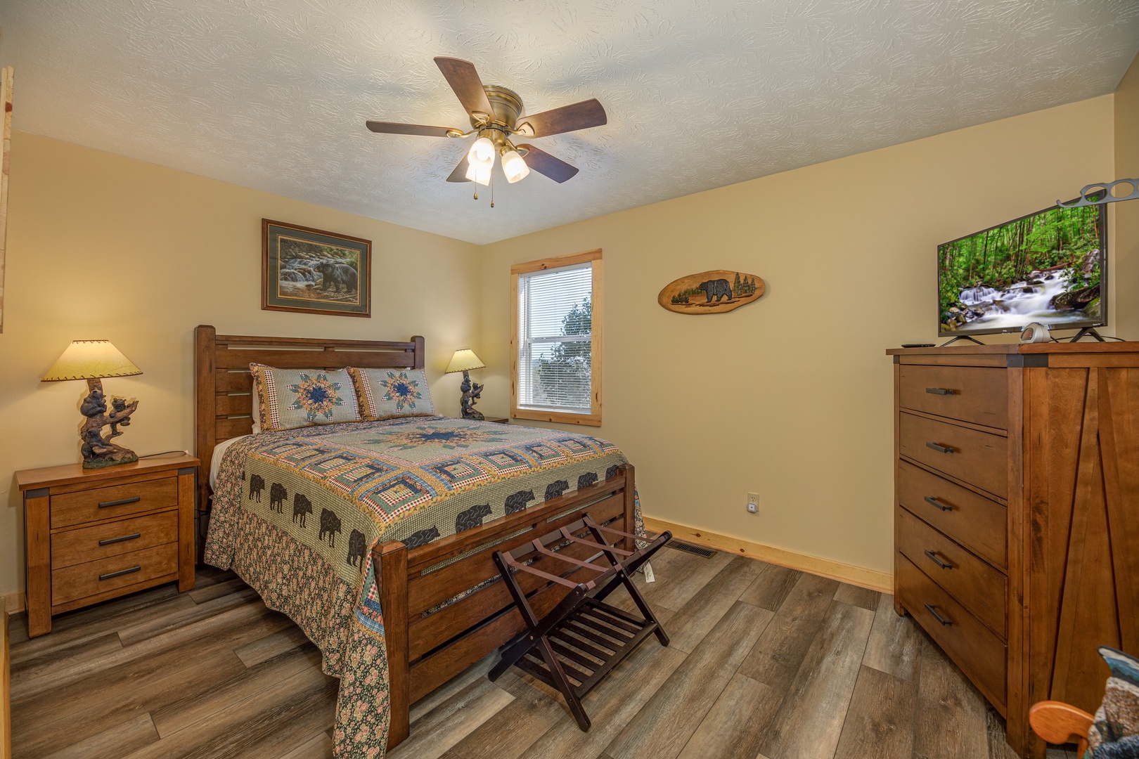 Bedroom with two night stands and lamps, dresser, and TV at Le Bear Chalet, a 7 bedroom cabin rental located in Gatlinburg