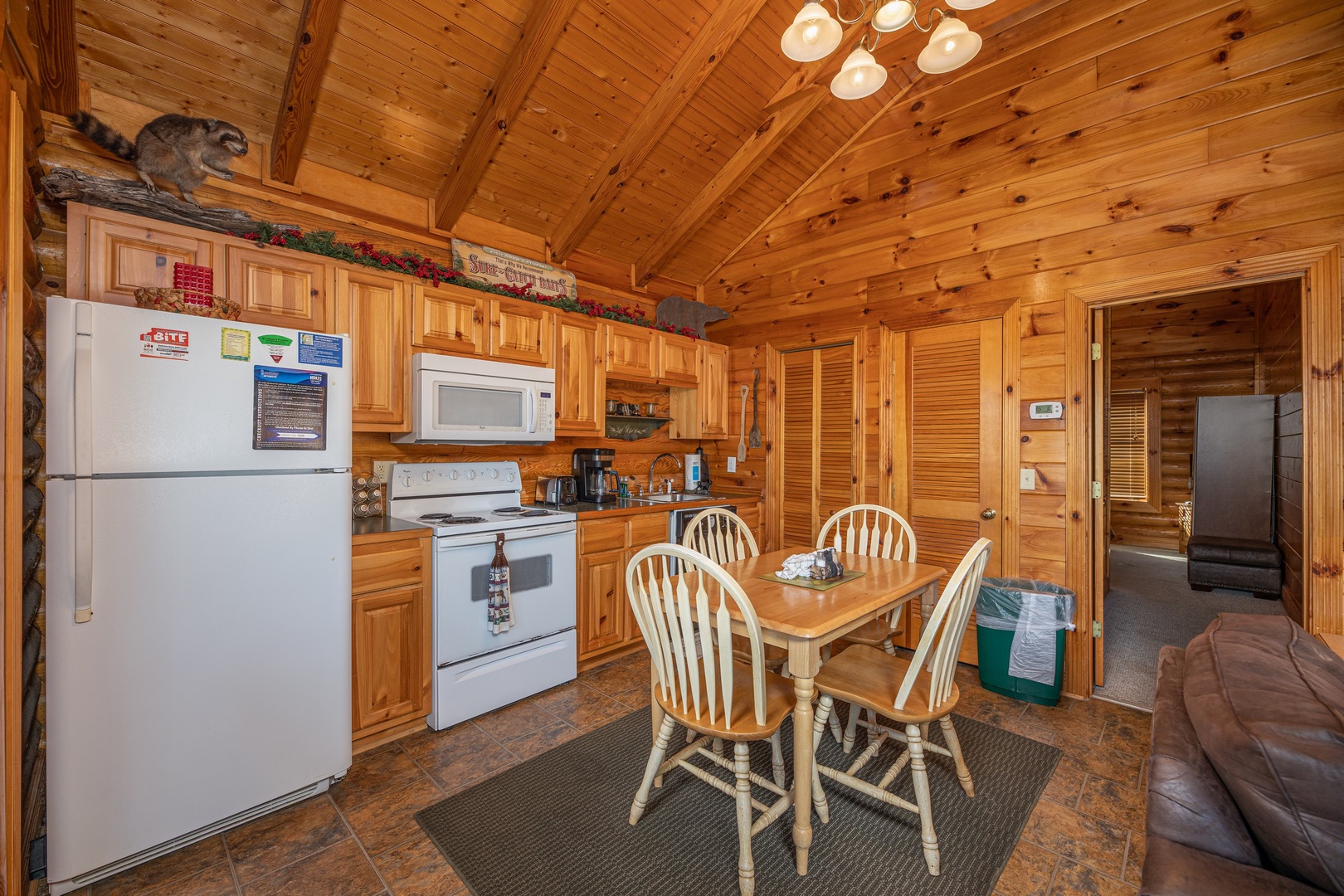 Kitchen with white appliances and dining space for 4 at Gone Fishin', a 2-bedroom cabin rental located in Pigeon Forge