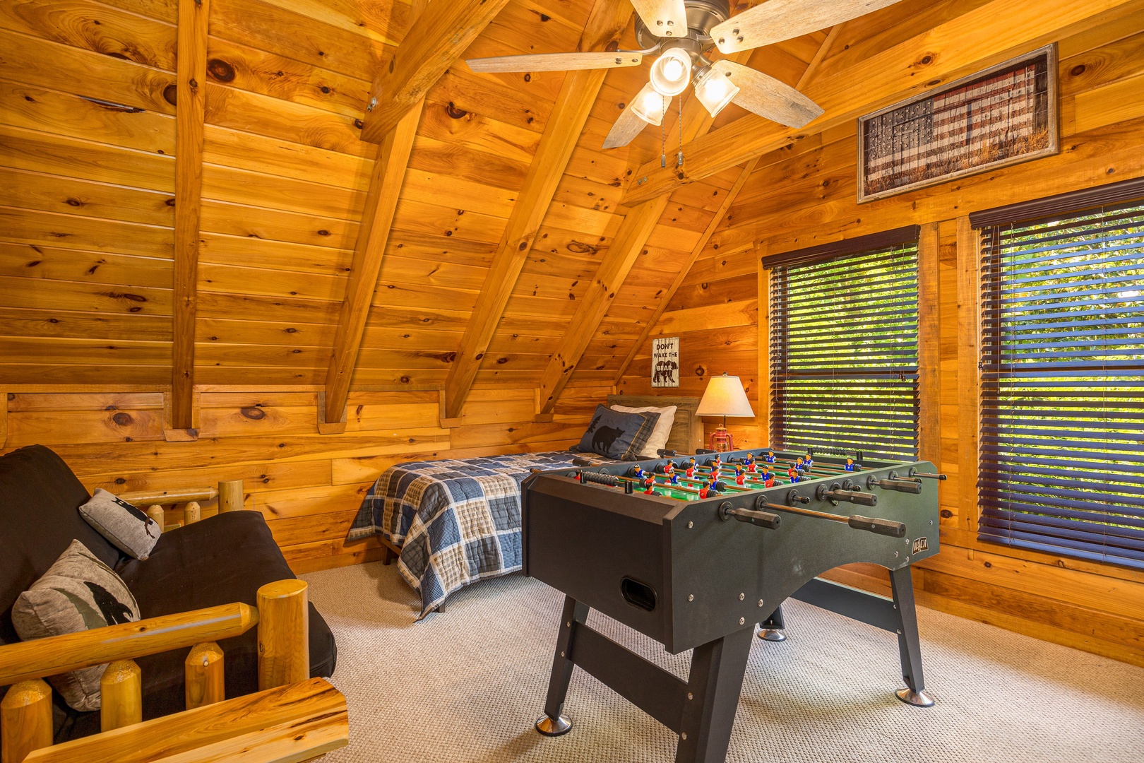 Foosball, futon, and twin bed in loft at Bear Feet Retreat, a 1 bedroom cabin rental located in pigeon forge