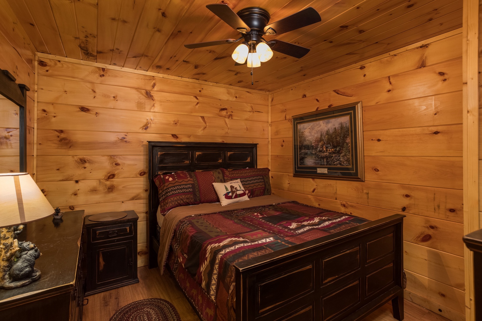 Bedroom with a bed, night stand, and dresser at Graceland, a 4-bedroom cabin rental located in Pigeon Forge