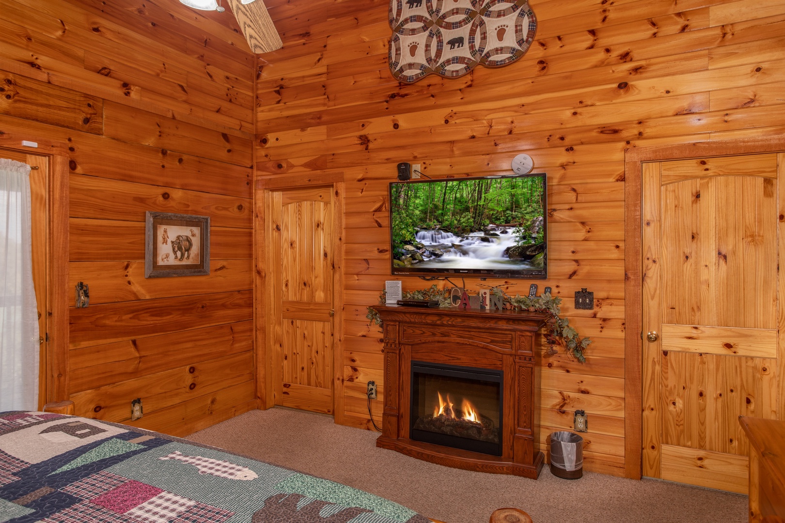 Bedroom with electric fireplace and television at Bear Country, a 3-bedroom cabin rental located in Pigeon Forge