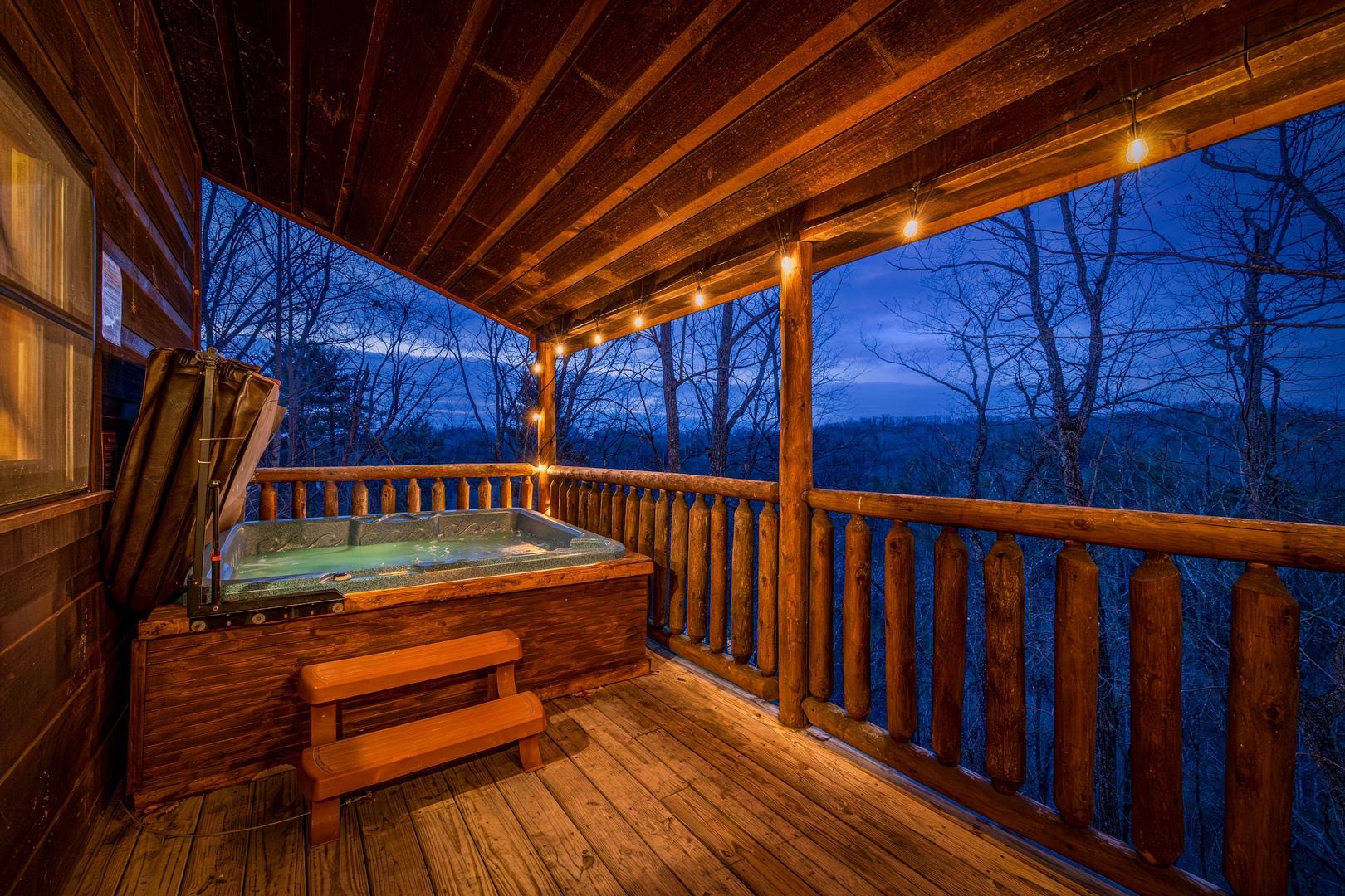 Hot tub at night on a covered deck at Moonshine Memories, a 2 bedroom cabin rental located in Gatlinburg