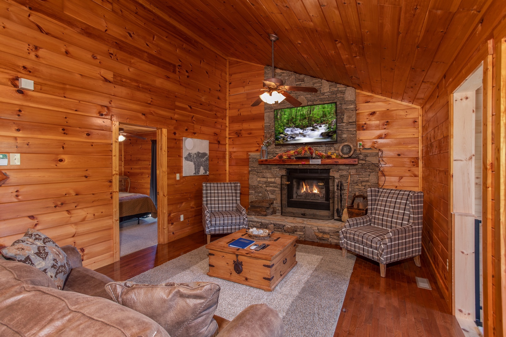 Living room with a fireplace and TV above at Cabin Fever, a 4-bedroom cabin rental located in Pigeon Forge