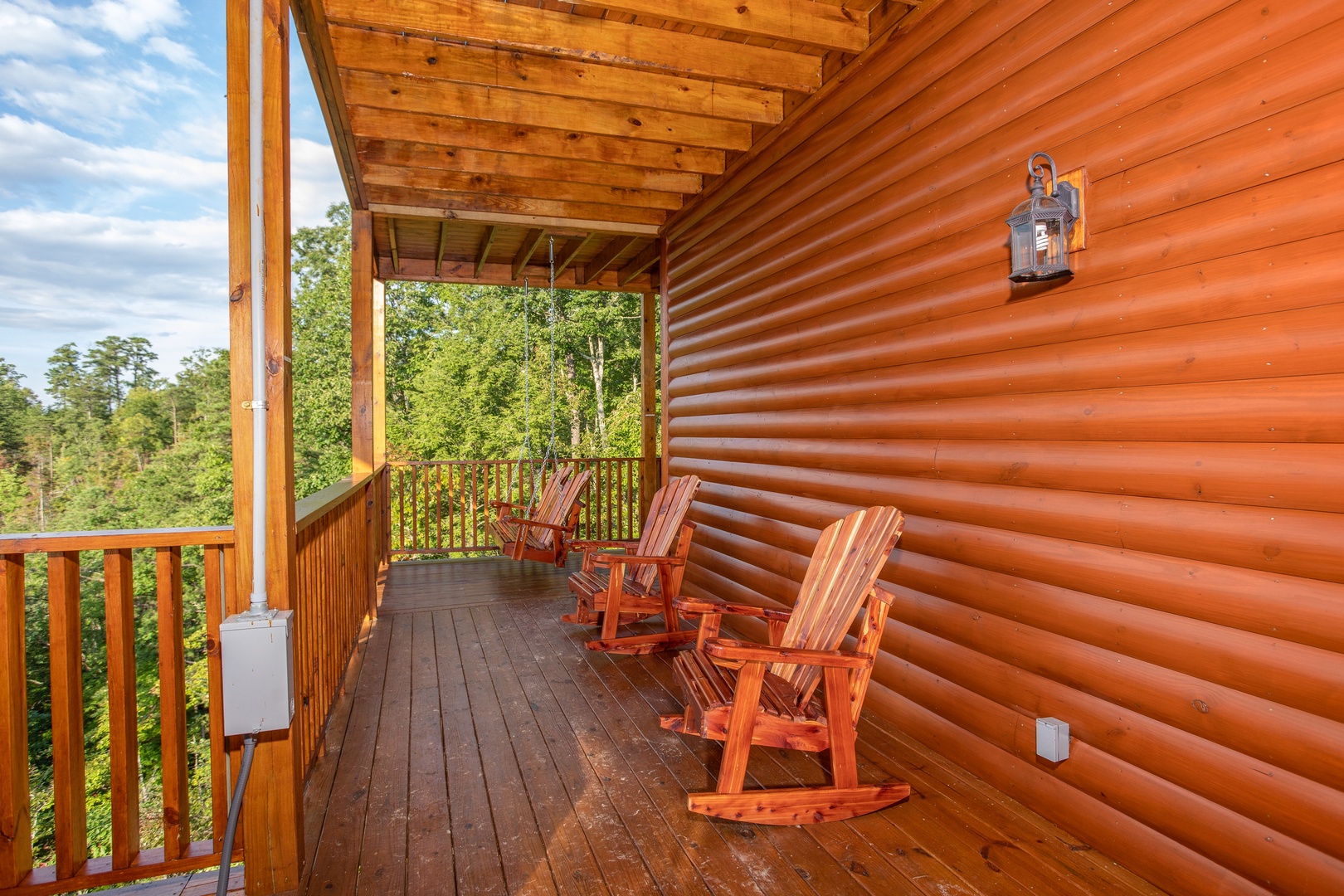Deck rockers in a row on a covered porch at Four Seasons Palace, a 5-bedroom cabin rental located in Pigeon Forge