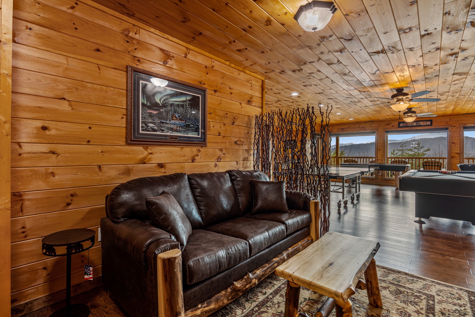 Leather couch in game room at Four Seasons Grand, a 5 bedroom cabin rental located in Pigeon Forge