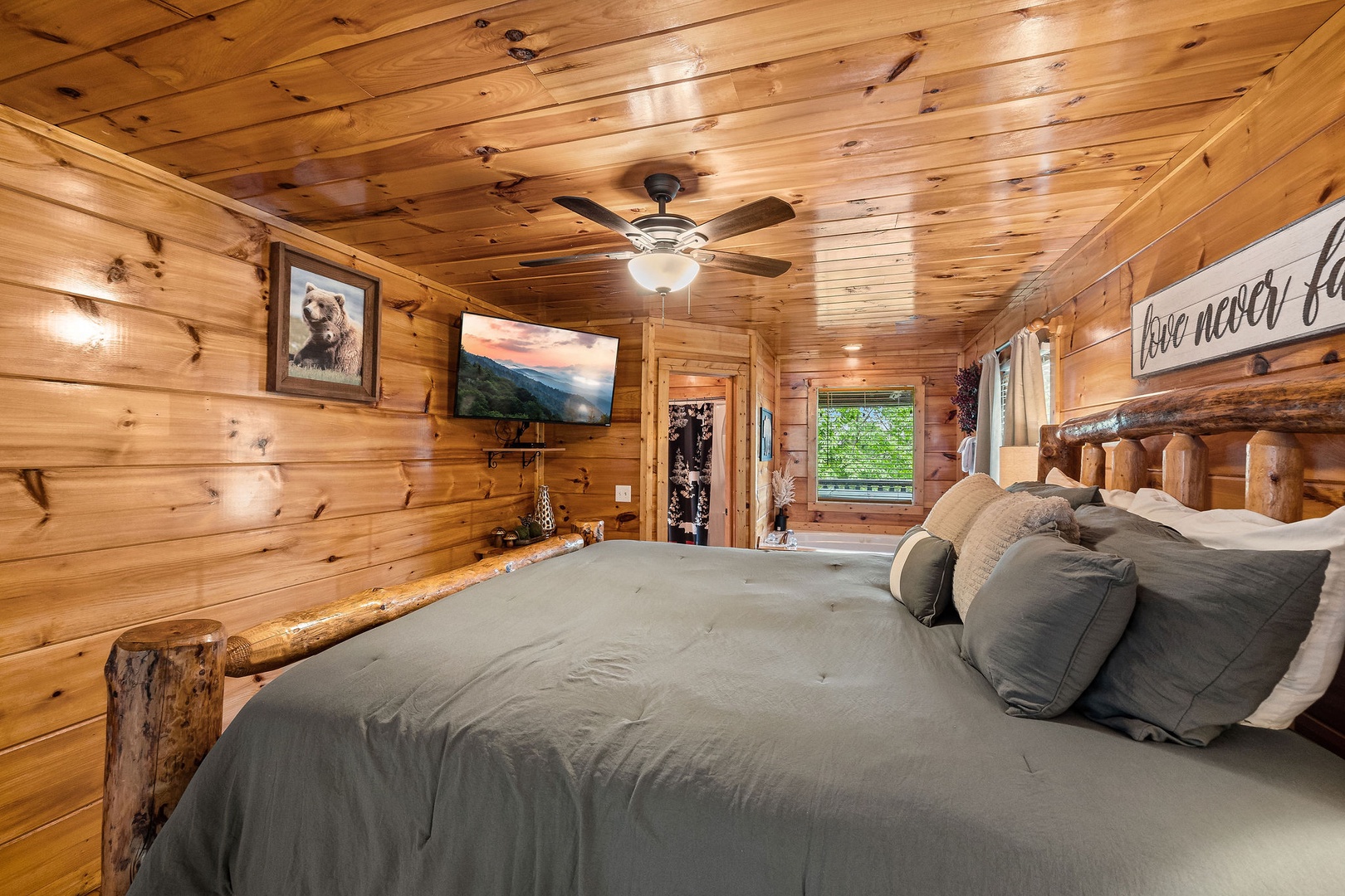 TV, jacuzzi, and bathroom at Honey Bear Haven, a 1 bedroom cabin rental located in Pigeon Forge