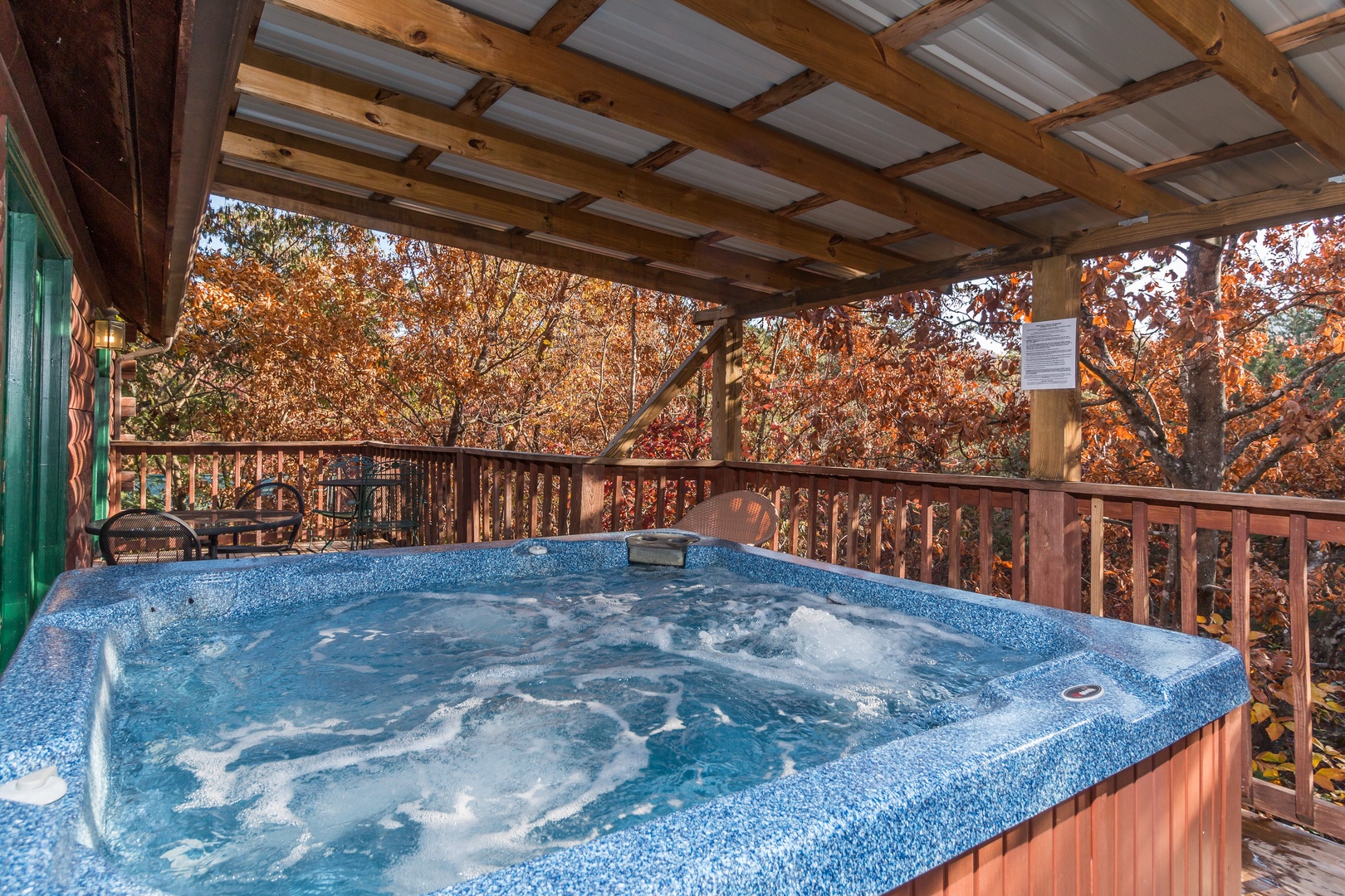 Hot tub on a covered deck at Just for Fun, a 4 bedroom cabin rental located in Pigeon Forge