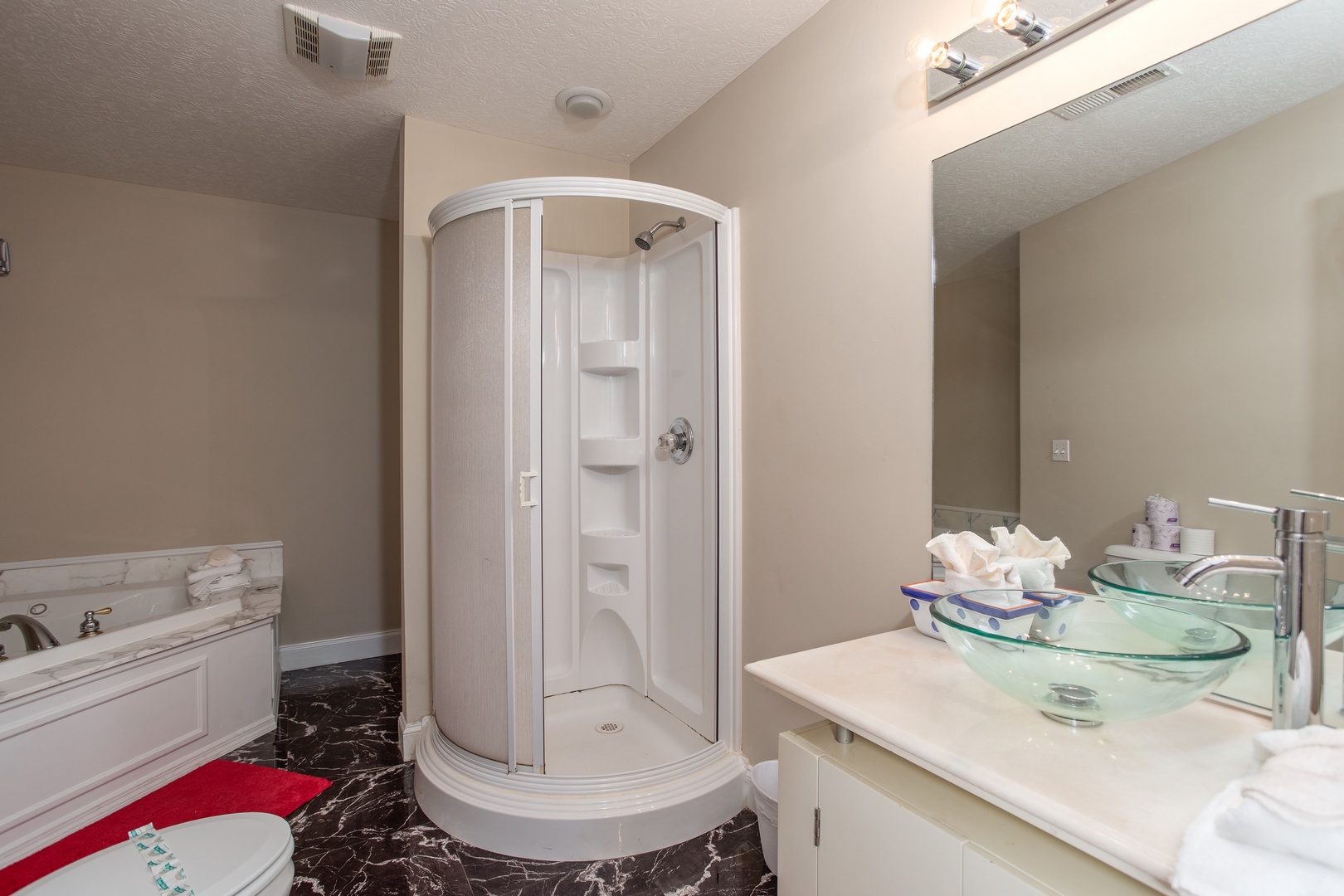 Jacuzzi in a corner with a separate shower in the bathroom at Into the Woods, a 3 bedroom cabin rental located in Pigeon Forge