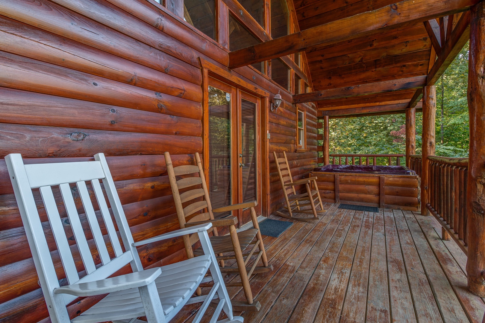 Rocking chairs on a covered deck at Lincoln Logs, a 2 bedroom cabin rental located in Gatlinburg