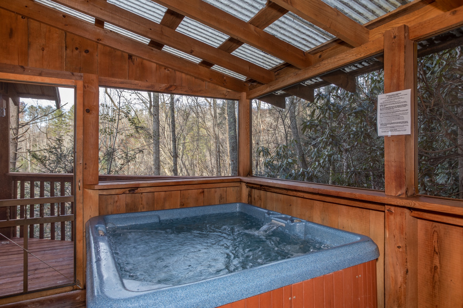 Hot tub on a covered deck at Moonshiner's Ridge, a 1-bedroom cabin rental located in Pigeon Forge