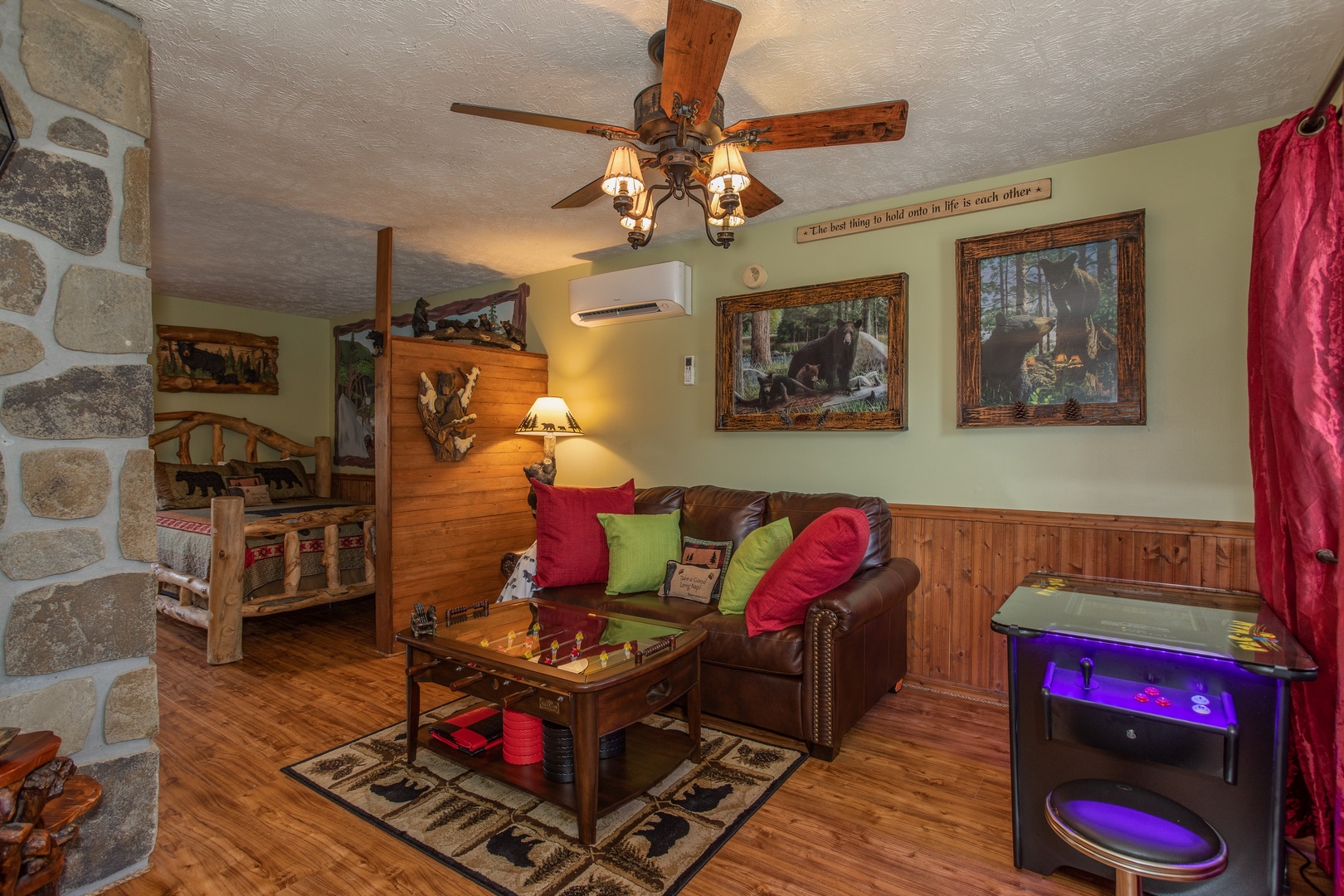Sleeper sofa and arcade game in the living room at Bear Mountain Hollow, a 1 bedroom cabin rental located in Pigeon Forge