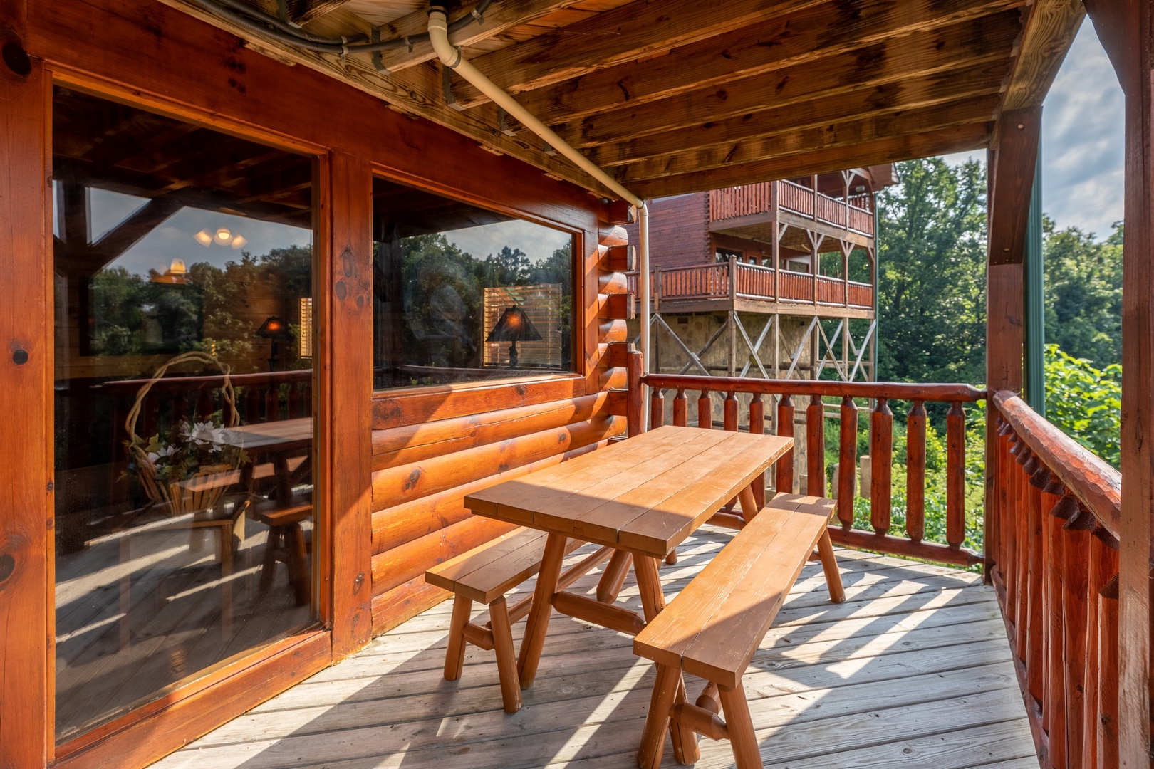 Picnic table on a covered deck at 1 Above the Smokies, a 2 bedroom cabin rental located in Pigeon Forge