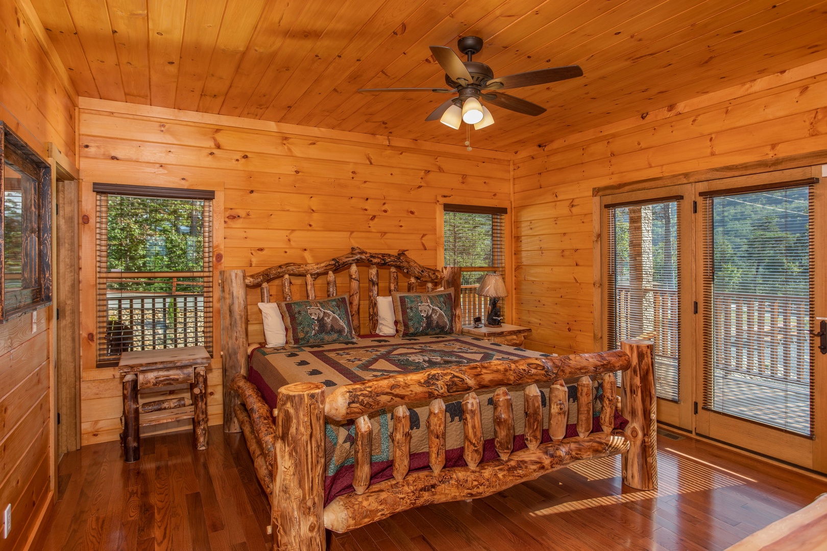 Bedroom with a log bed and deck access at Four Seasons Palace, a 5-bedroom cabin rental located in Pigeon Forge