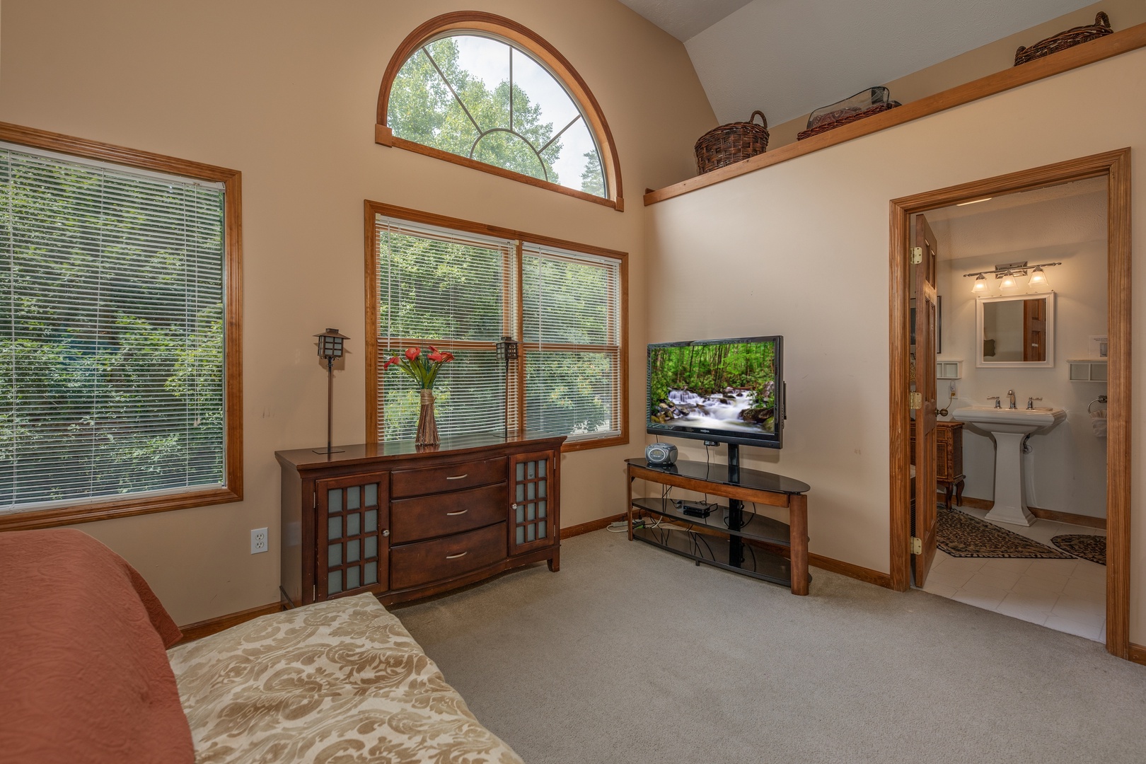 Dresser, tv, and en suite bath at Amazing Memories, a 3 bedroom cabin rental located in Pigeon Forge