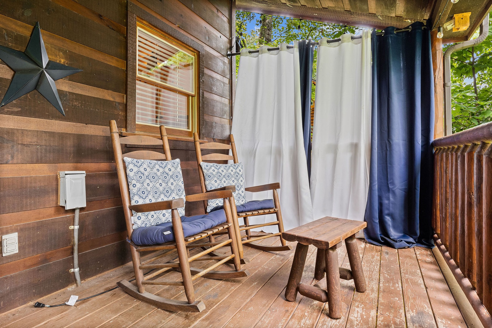 Rocking chairs on a covered deck at Honey Bear Haven, a 1 bedroom cabin rental located in Pigeon Forge