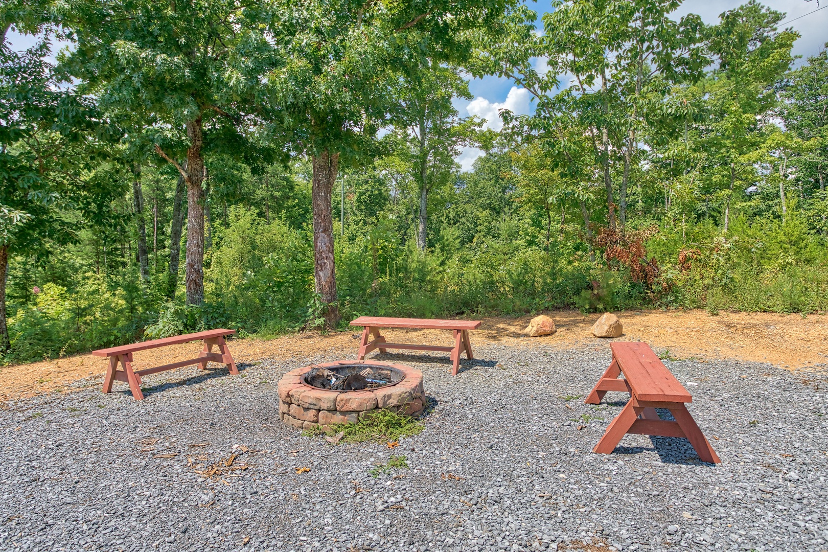 Fire pit with three benches at Four Seasons Lodge, a 3-bedroom cabin rental located in Pigeon Forge