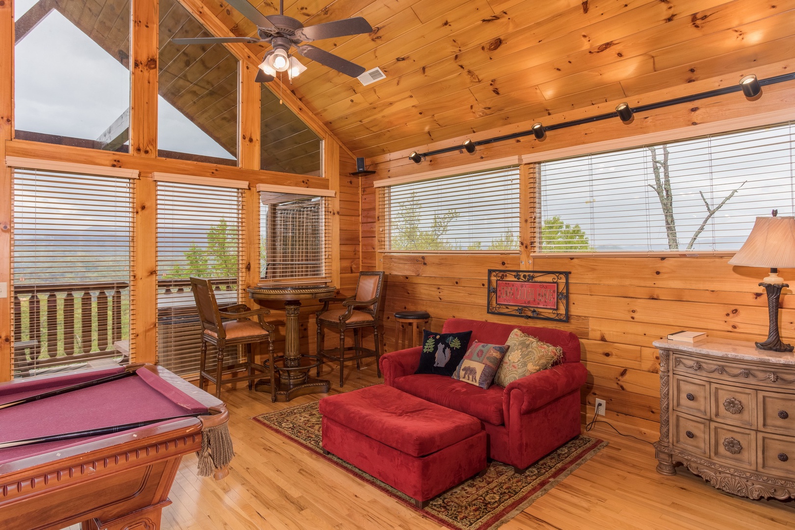 Table and two chairs, over-sized chair with ottoman, and pool table in the loft space at Howlin' in the Smokies, a 2 bedroom cabin rental located in Pigeon Forge
