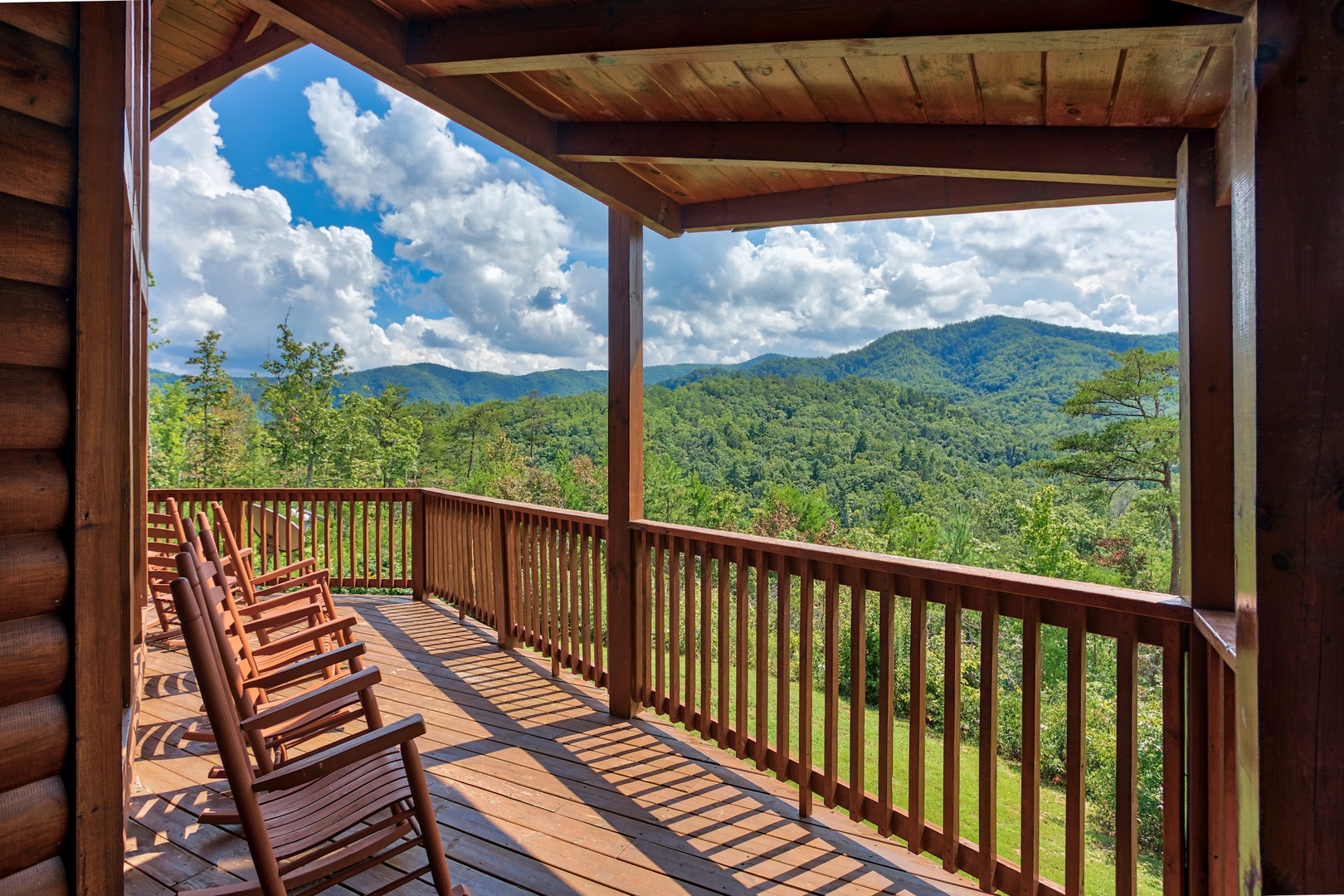 Rocking chairs on the covered deck with mountain views at Four Seasons Lodge, a 3-bedroom cabin rental located in Pigeon Forge