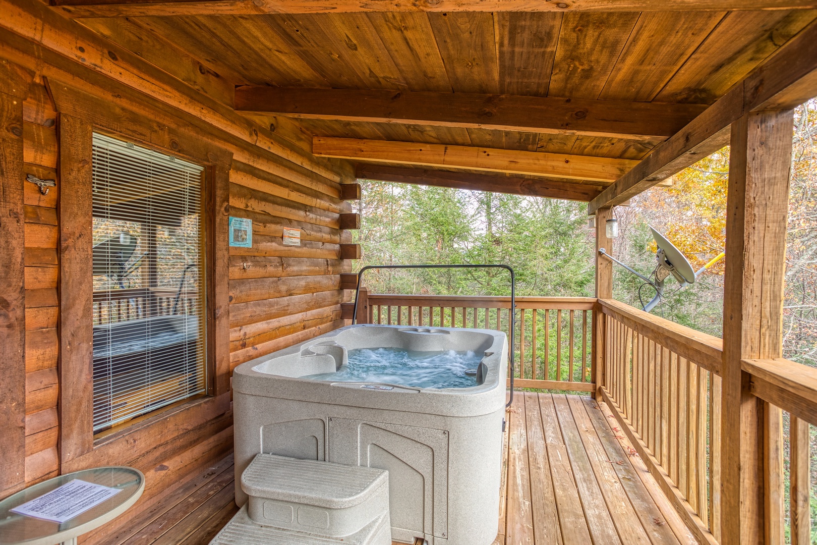 Hot tub on a covered deck at Enchanted Evening, a 1-bedroom cabin rental located in Pigeon Forge