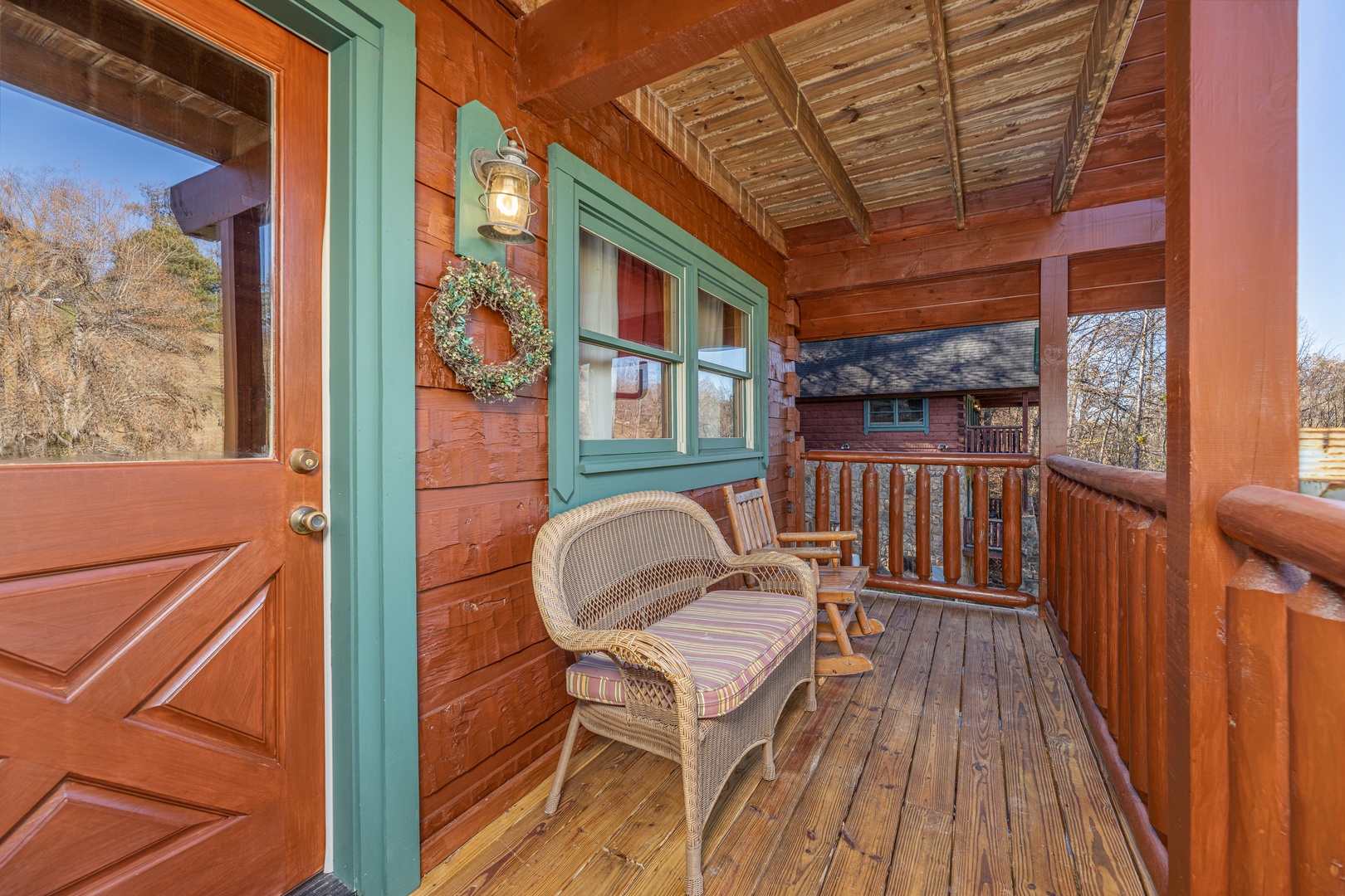 Wicker bench and small rocking chair on the front porch at A Beary Nice Cabin, a 2 bedroom cabin rental located in Pigeon Forge
