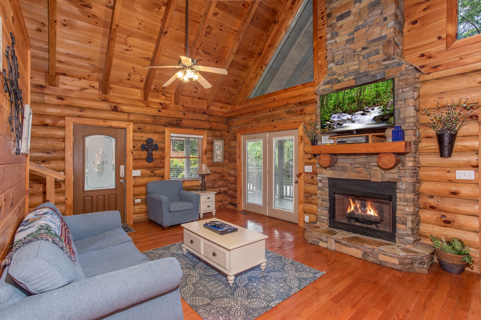 living room with vaulted ceiling and stone fireplace at alpine something blue a 1 bedroom cabin rental located in pigeon forge