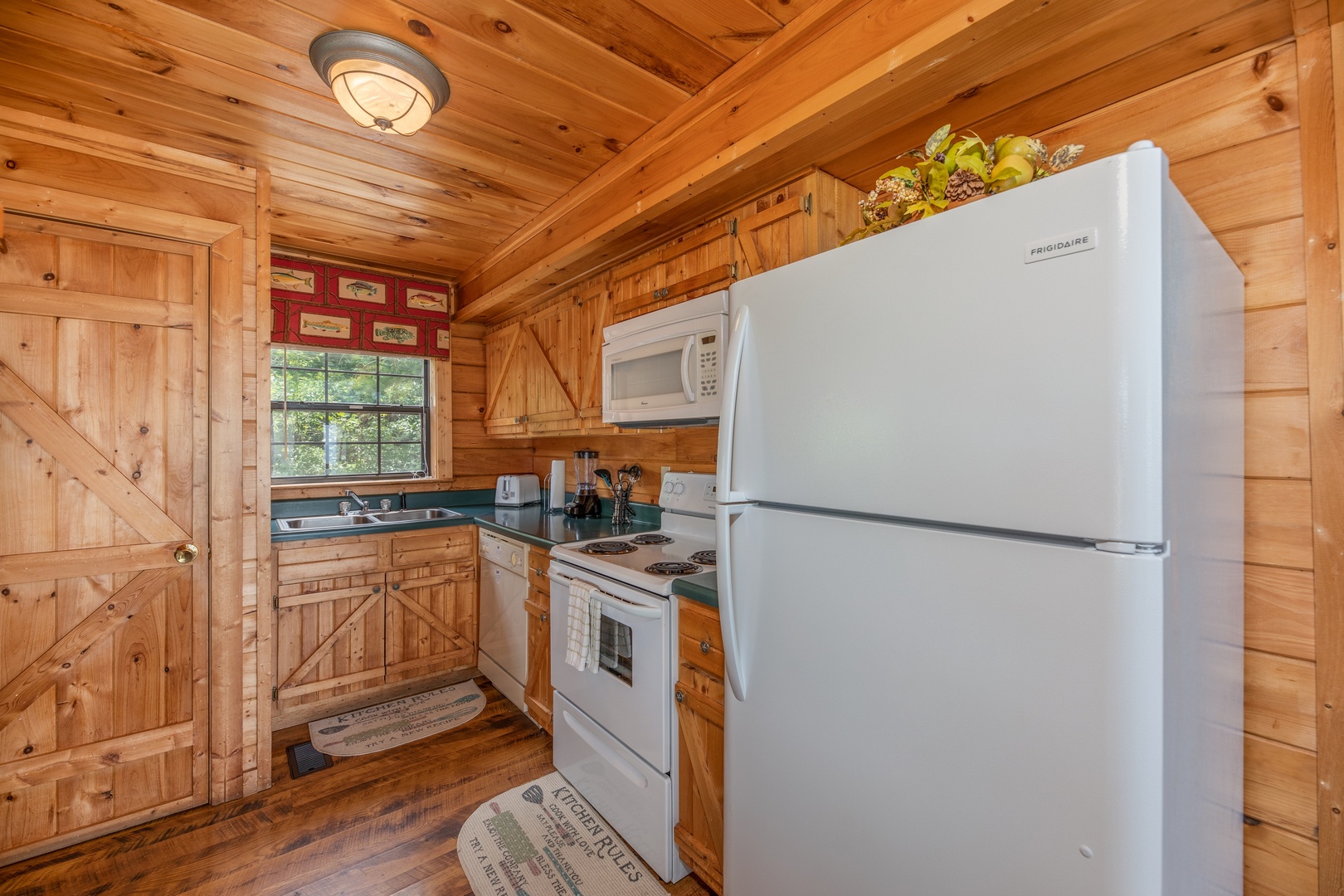 Kitchen with white appliances at Away From it All, a 1 bedroom cabin rental located in Pigeon Forge